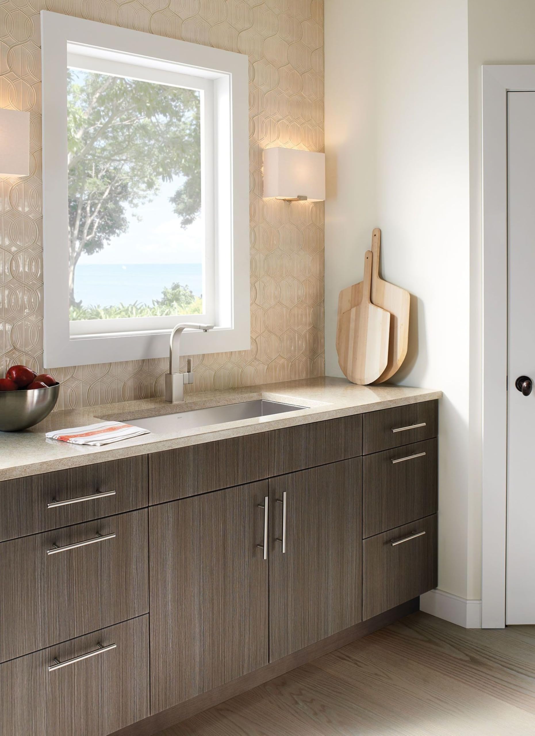 Stainless steel undermount kitchen sink installed in countertop with single bowl basin and chrome faucet.