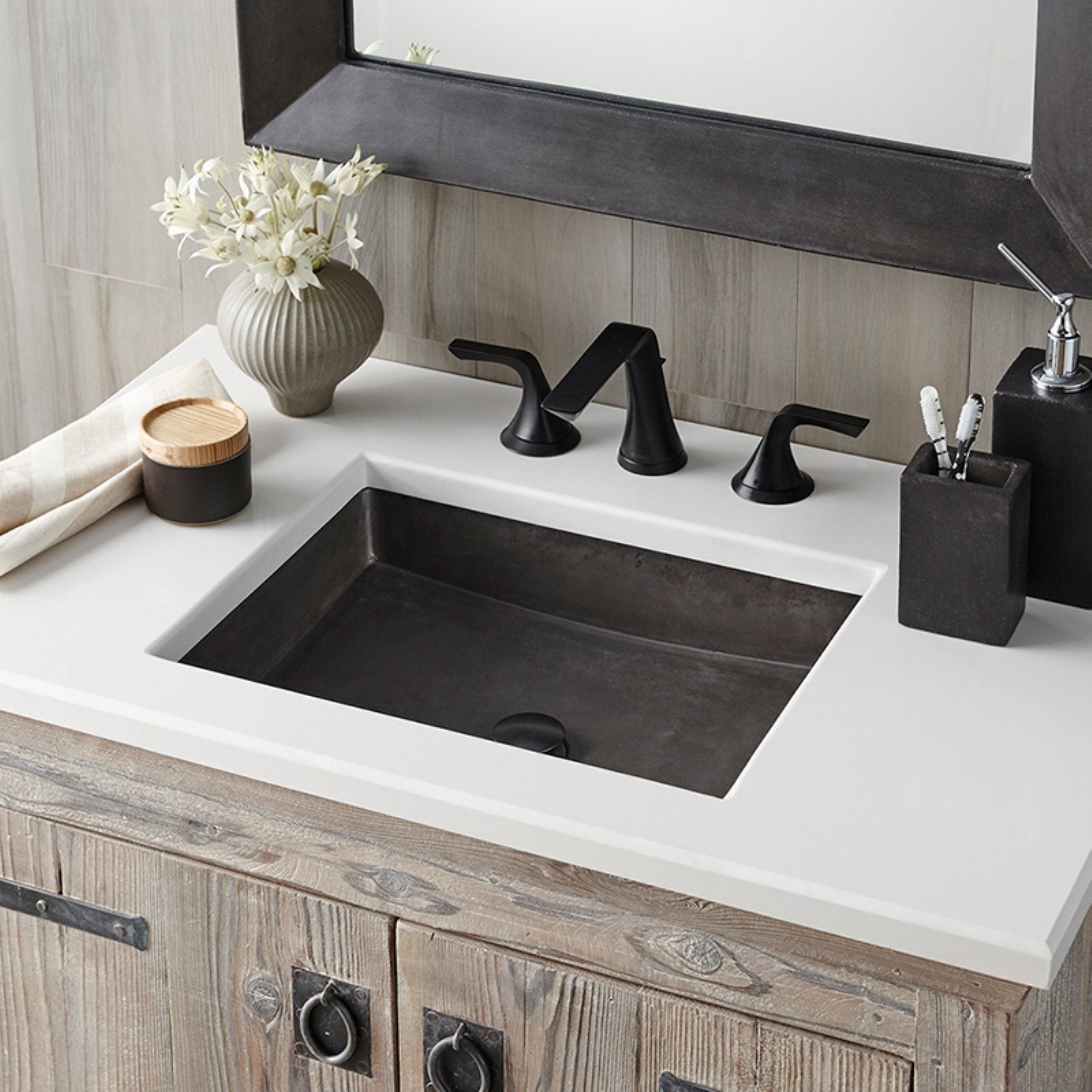 Slate rectangular undermount sink with white countertop and black three-hole faucet in bathroom vanity.