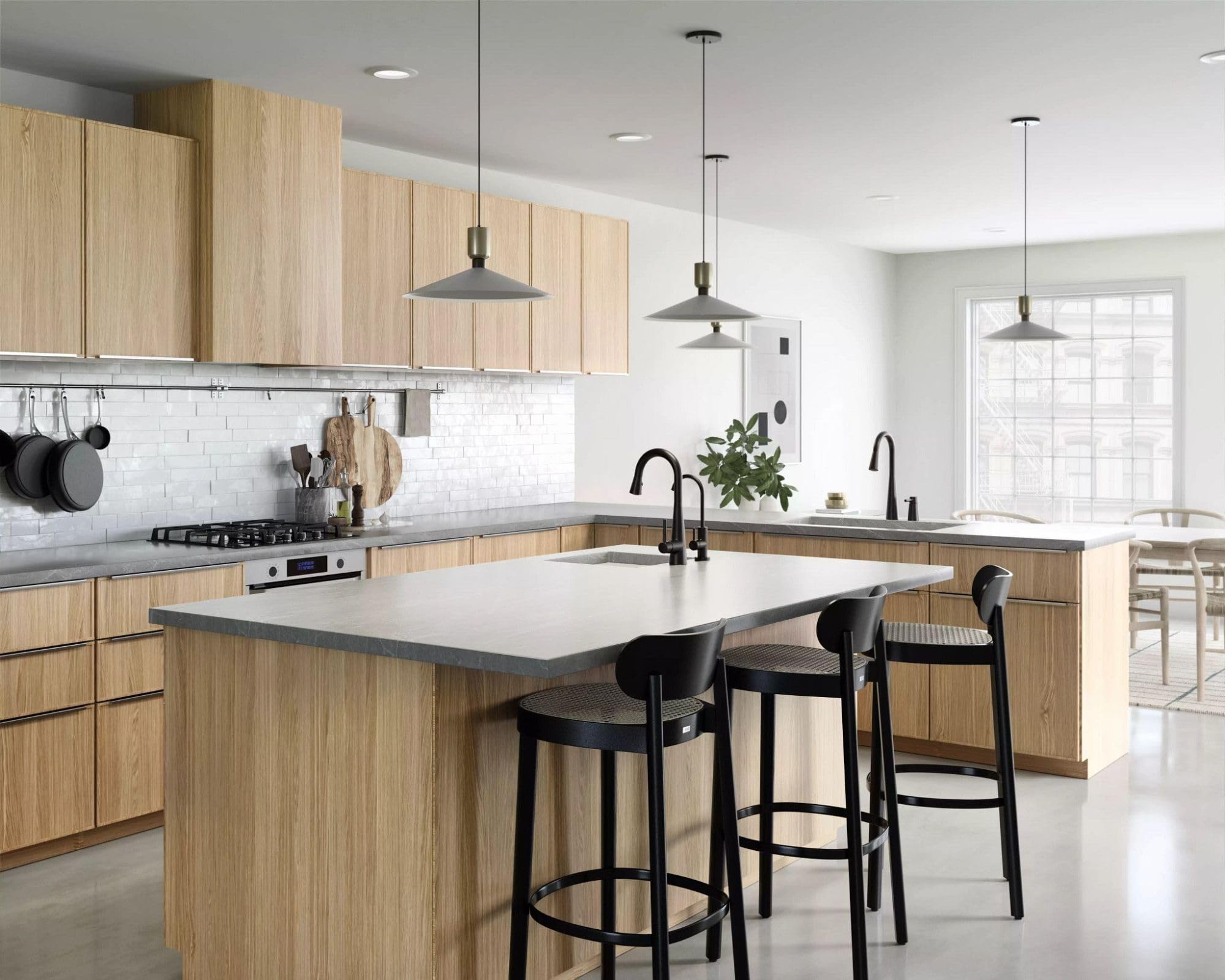 Matte black single-handle high arc pulldown faucet with curved spout installed at kitchen sink.