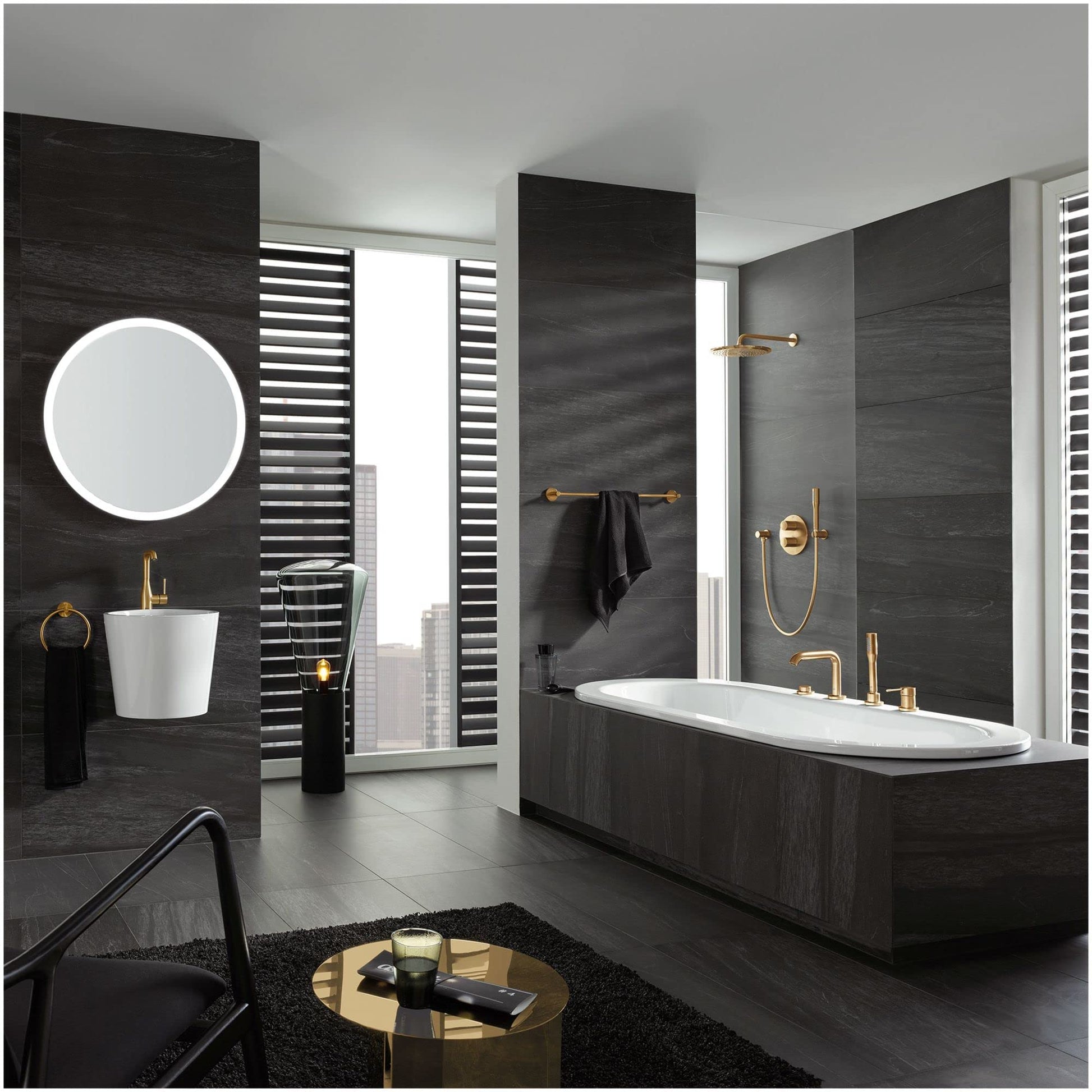 Matte black circular towel ring mounted on dark tile bathroom wall above bathtub.