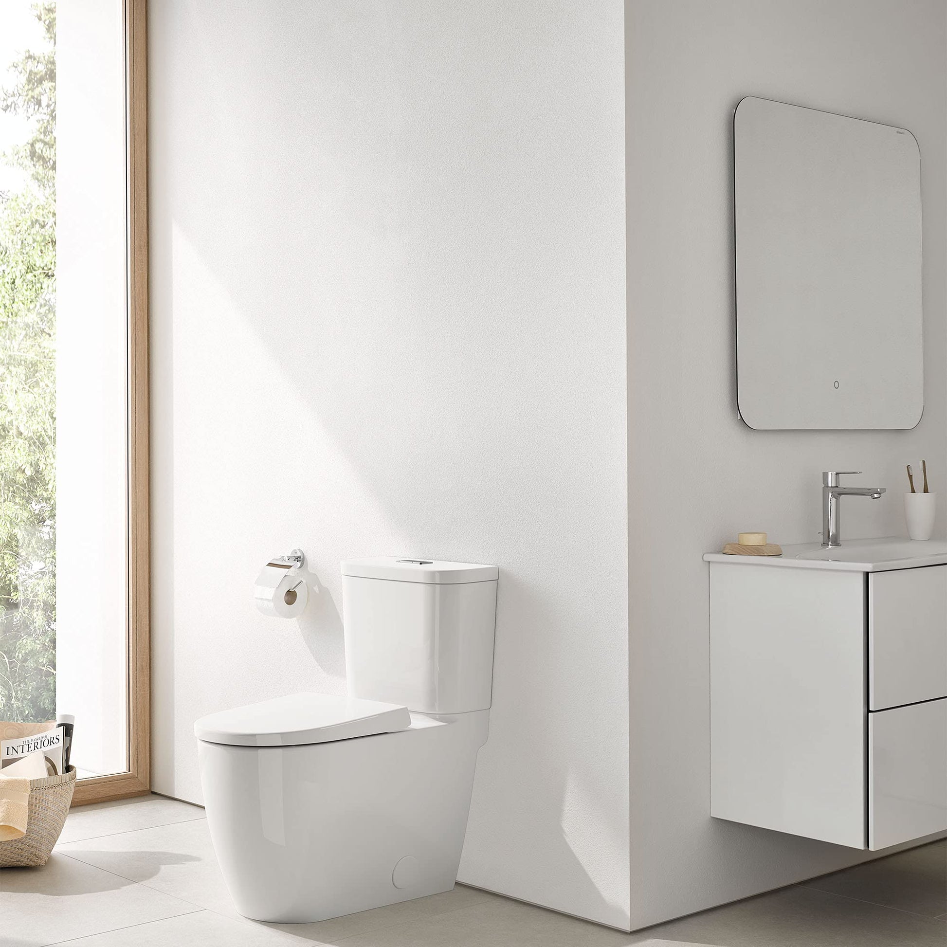 White two-piece elongated toilet with seat and left-hand trip lever in modern bathroom setting.