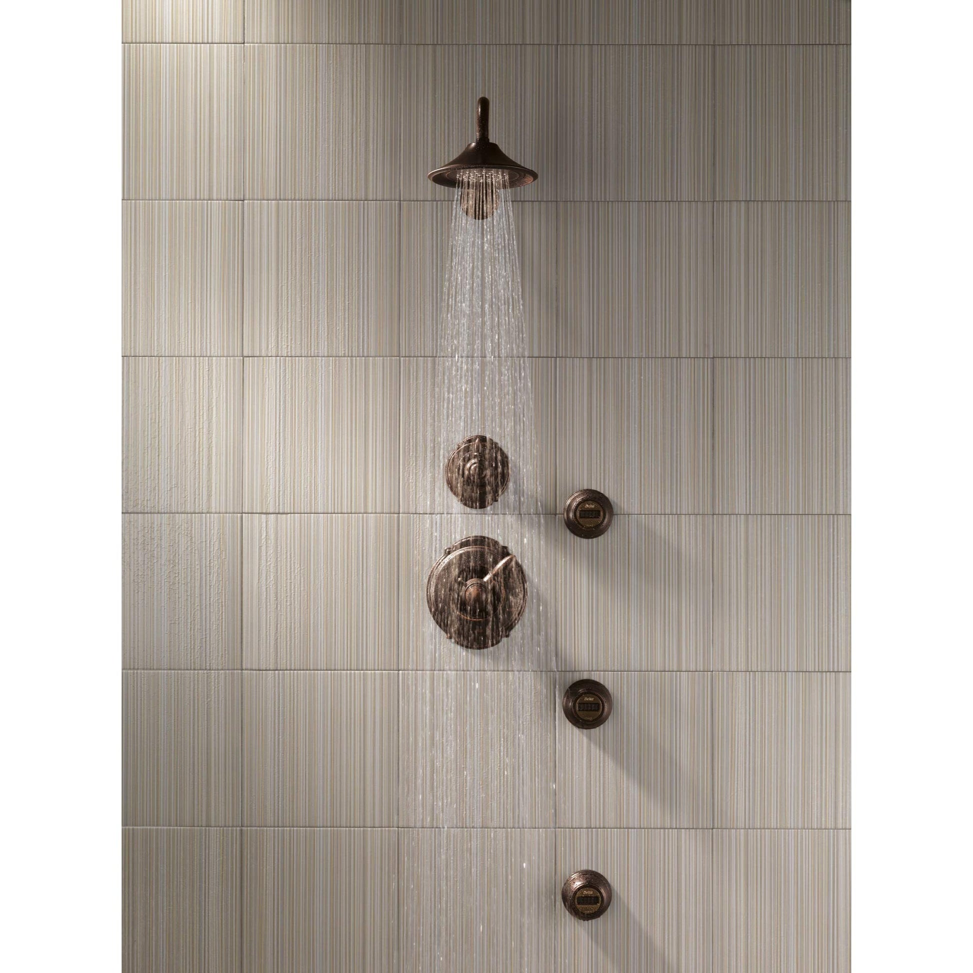 Venetian bronze shower head with water stream flowing downward, mounted above two round wall controls and three additional br