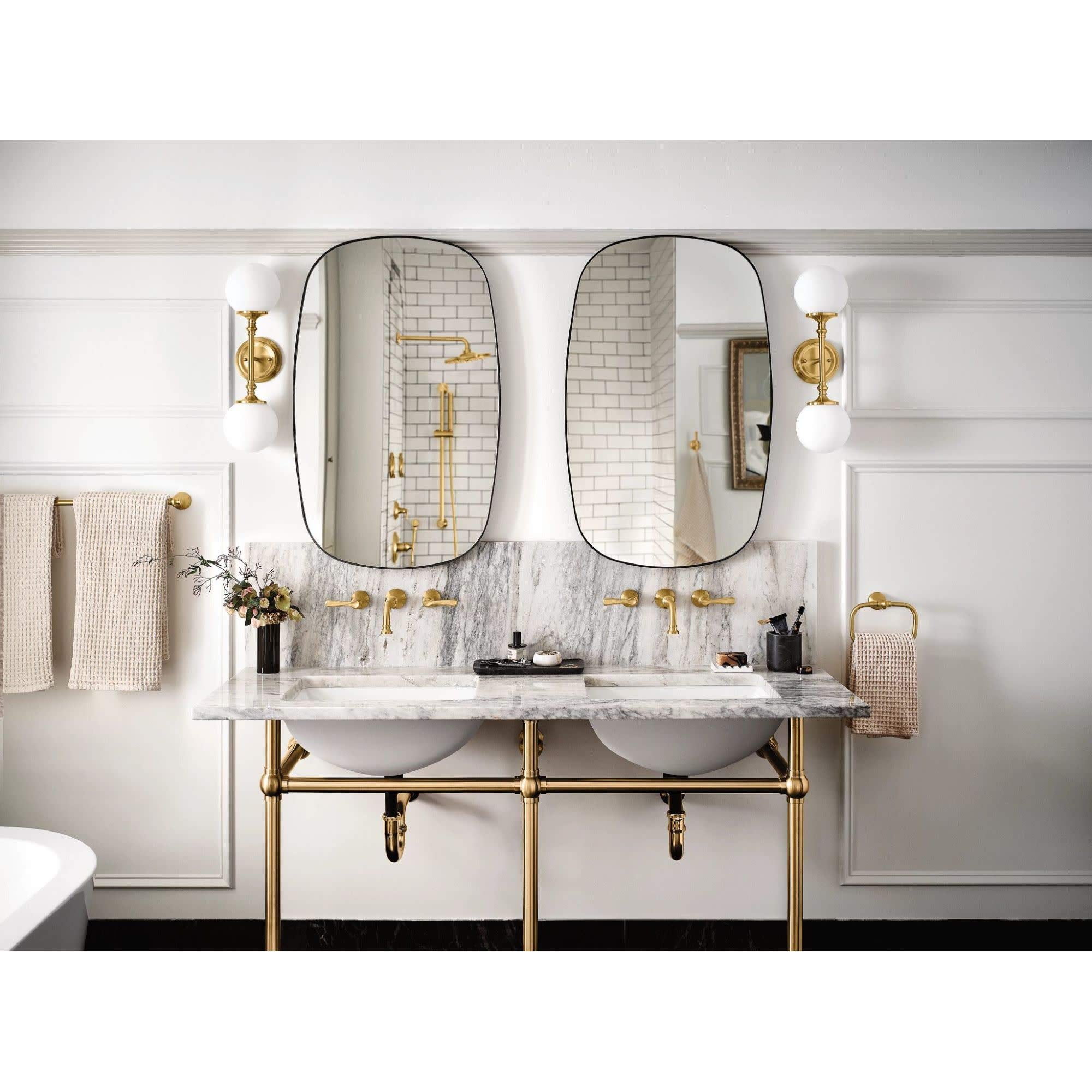 Matte black wall-mounted bathroom faucet trim with traditional lever handle and spout mounted above marble countertop.