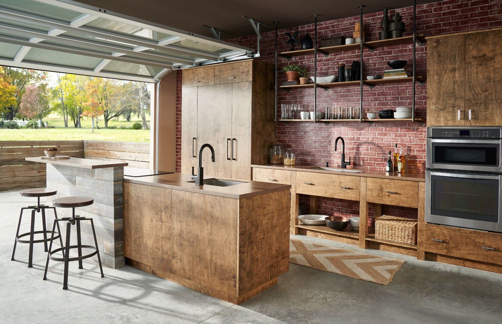 Matte black countertop soap and lotion dispenser with pump mechanism displayed in modern kitchen setting.