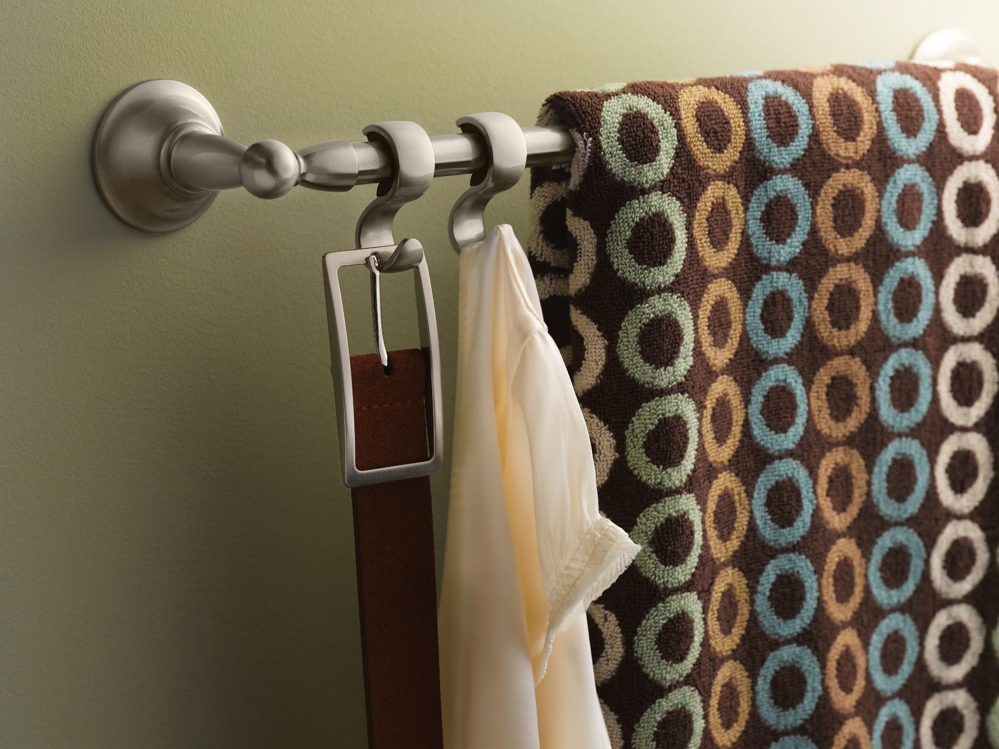 Brushed nickel double towel bar mounted on wall with two towels hanging from the rod and hooks.