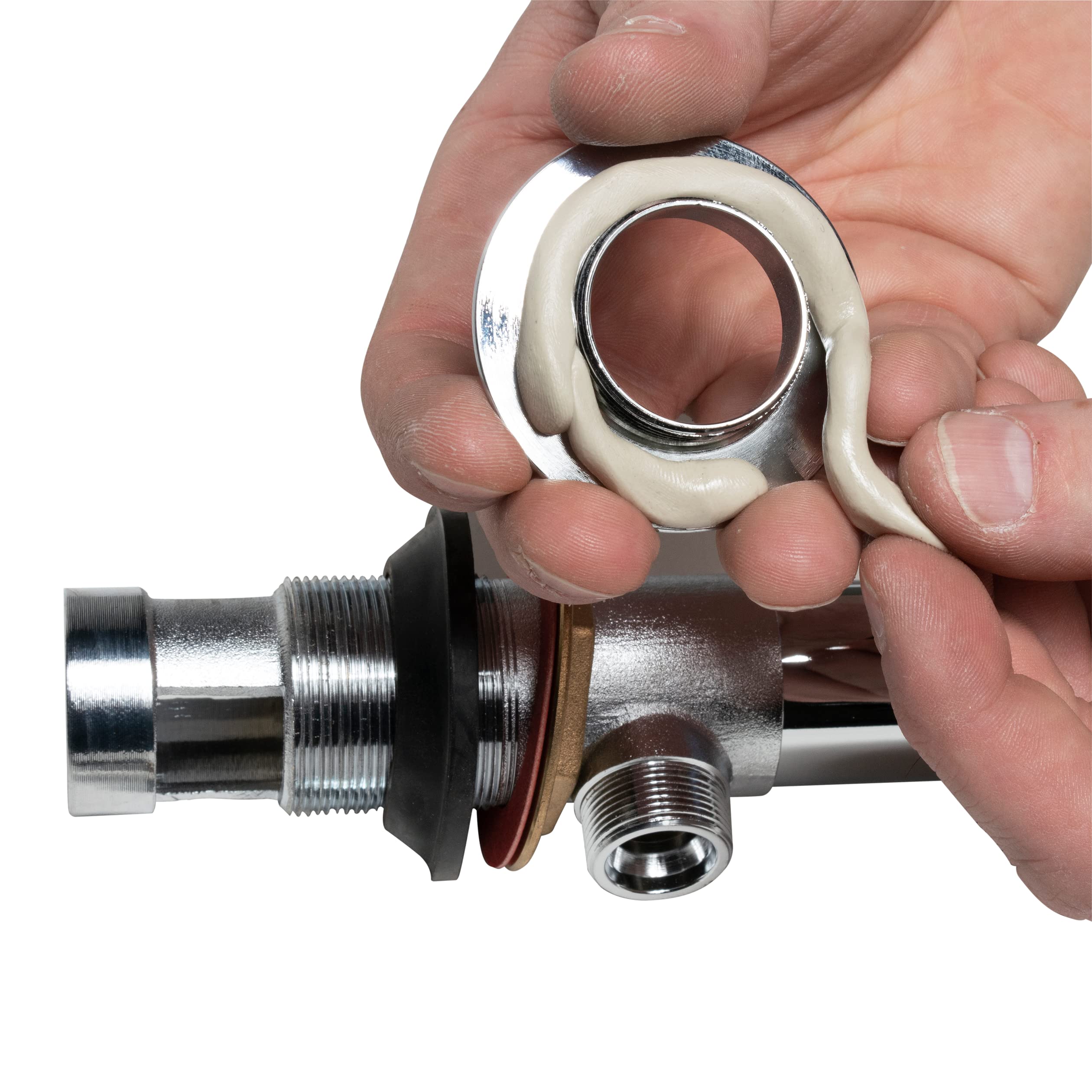 Beige plumber's putty being applied around metal pipe fitting threads by hand.