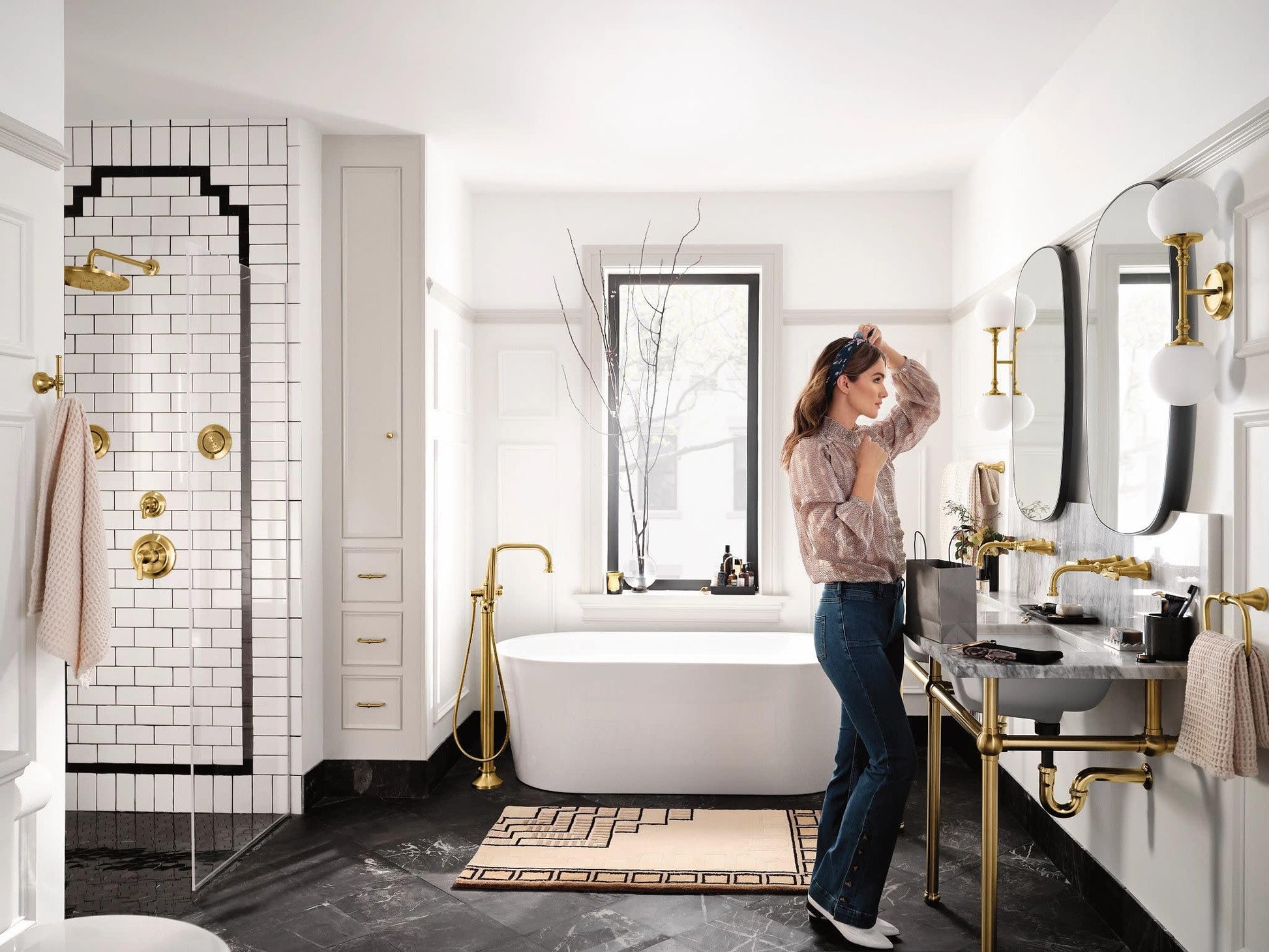 Brushed gold single-handle valve trim kit installed on bathroom sink faucet in modern bathroom setting.