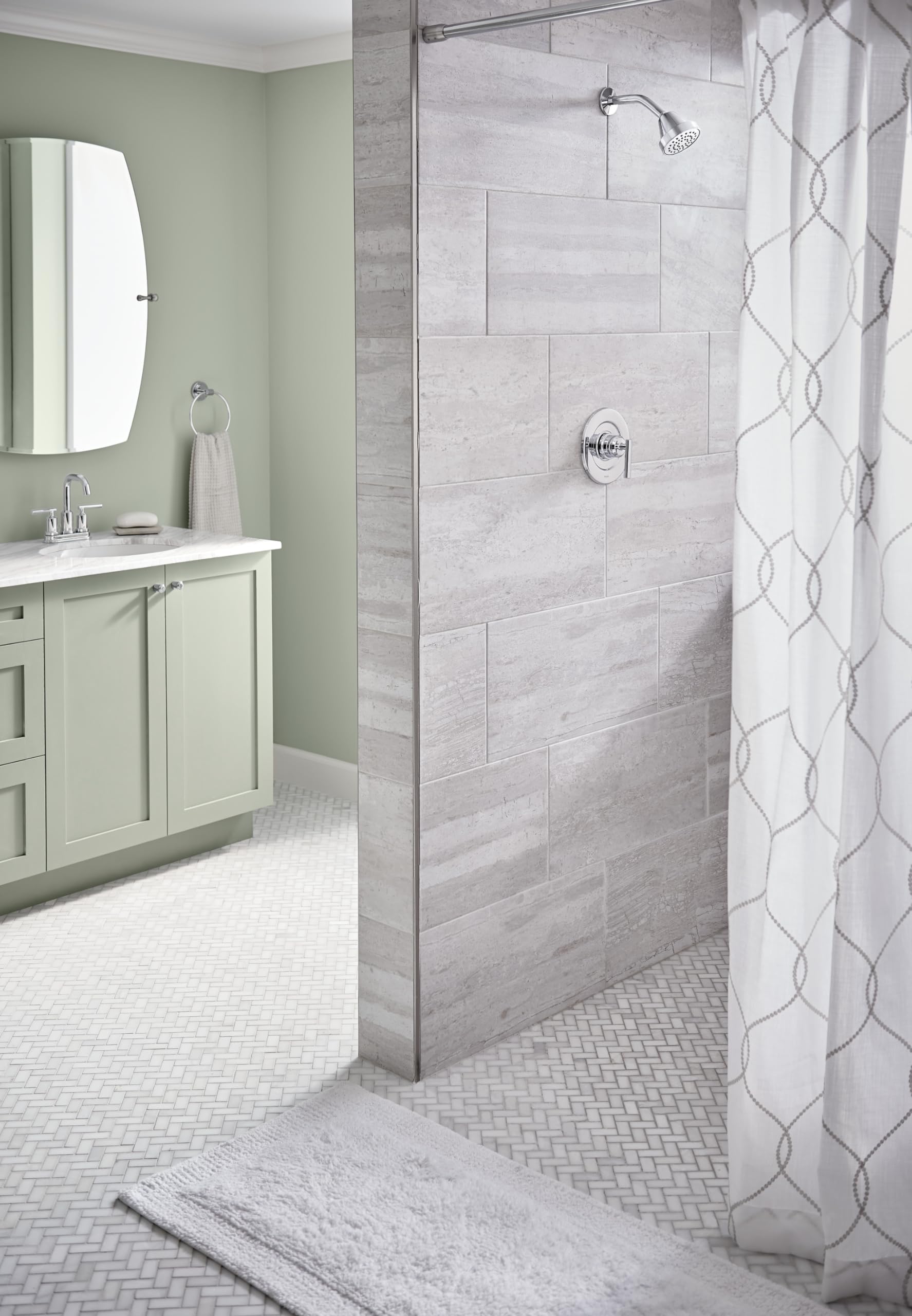 Chrome single-handle shower trim kit mounted on gray tile wall with showerhead and control valve visible.