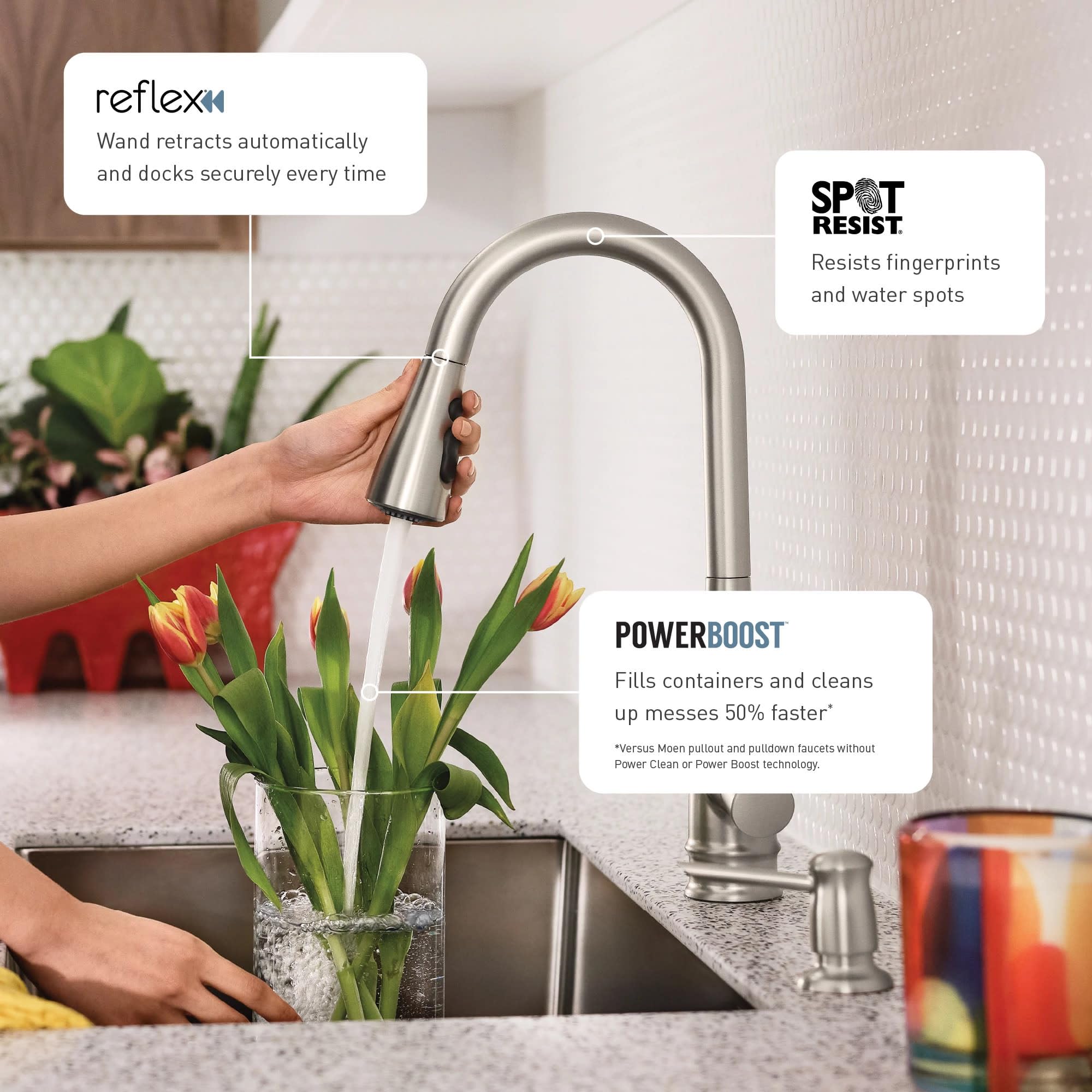 Stainless steel pull-down kitchen faucet with side handle being used to fill a vase of flowers at a sink.
