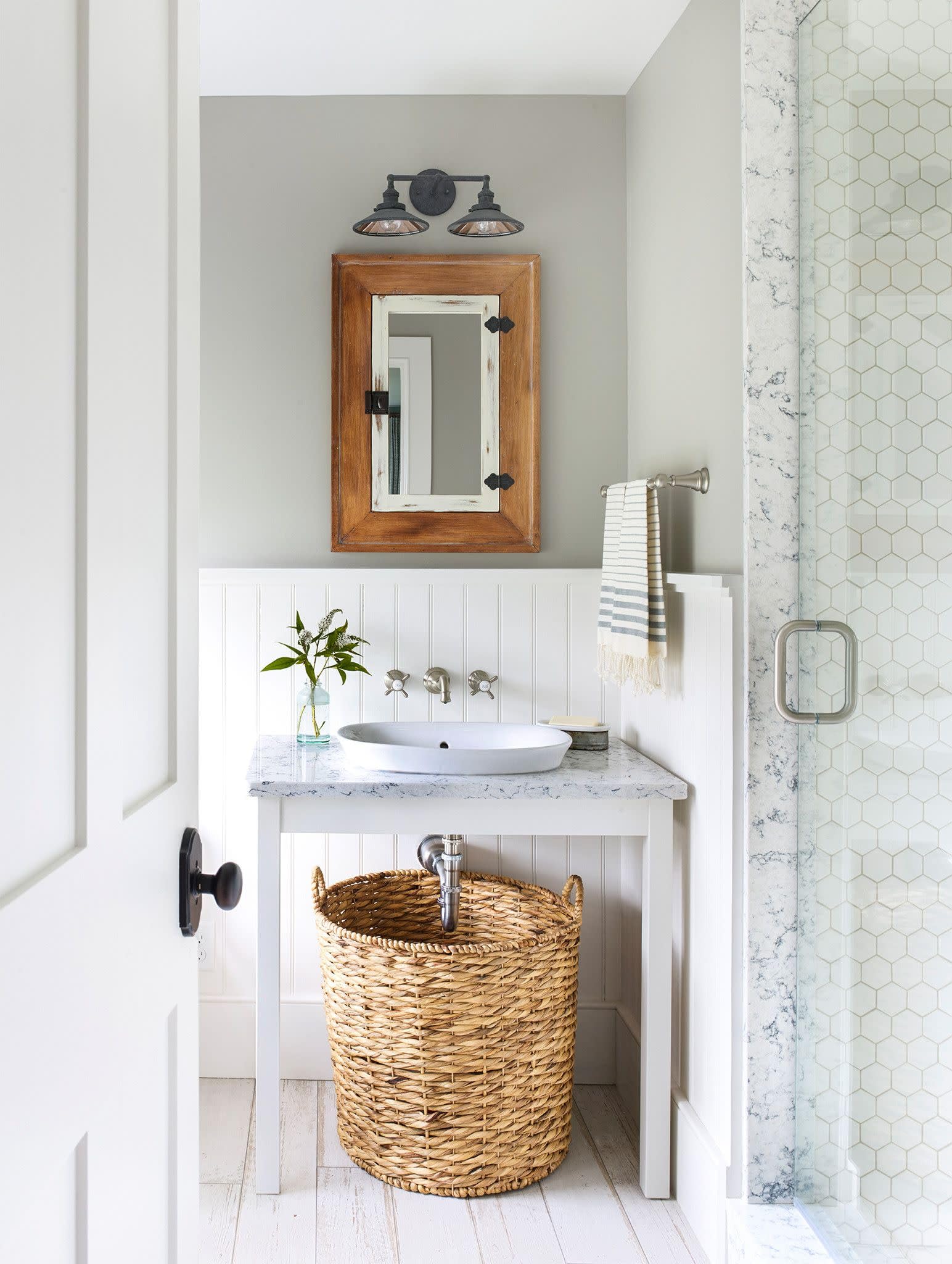 Brushed nickel wall-mounted bathroom faucet trim with cross handles installed above a white sink.