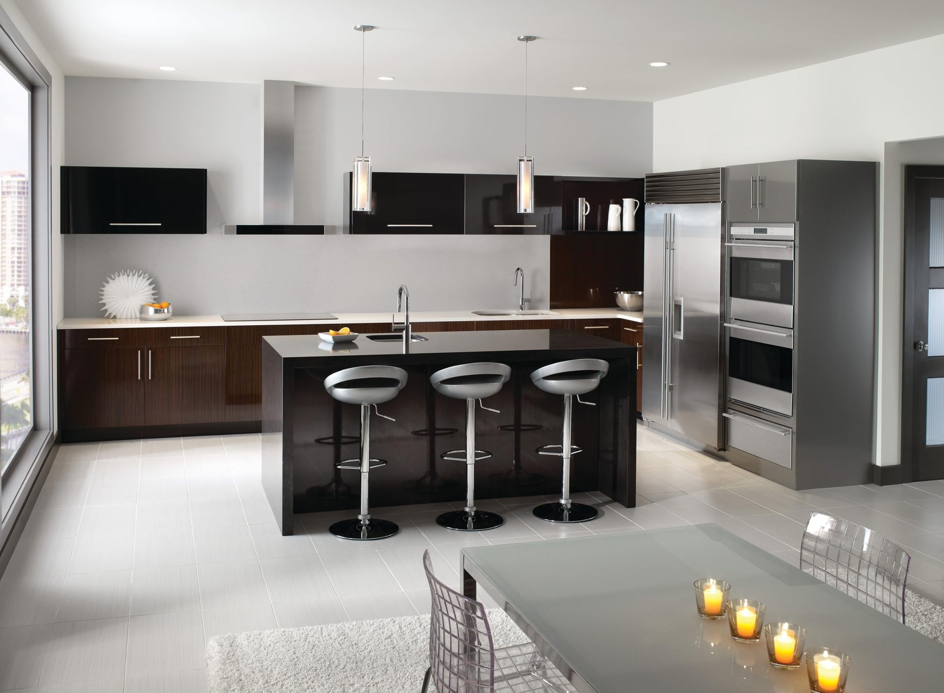 Chrome single-handle pulldown kitchen faucet mounted above sink in modern kitchen with black and white cabinetry.