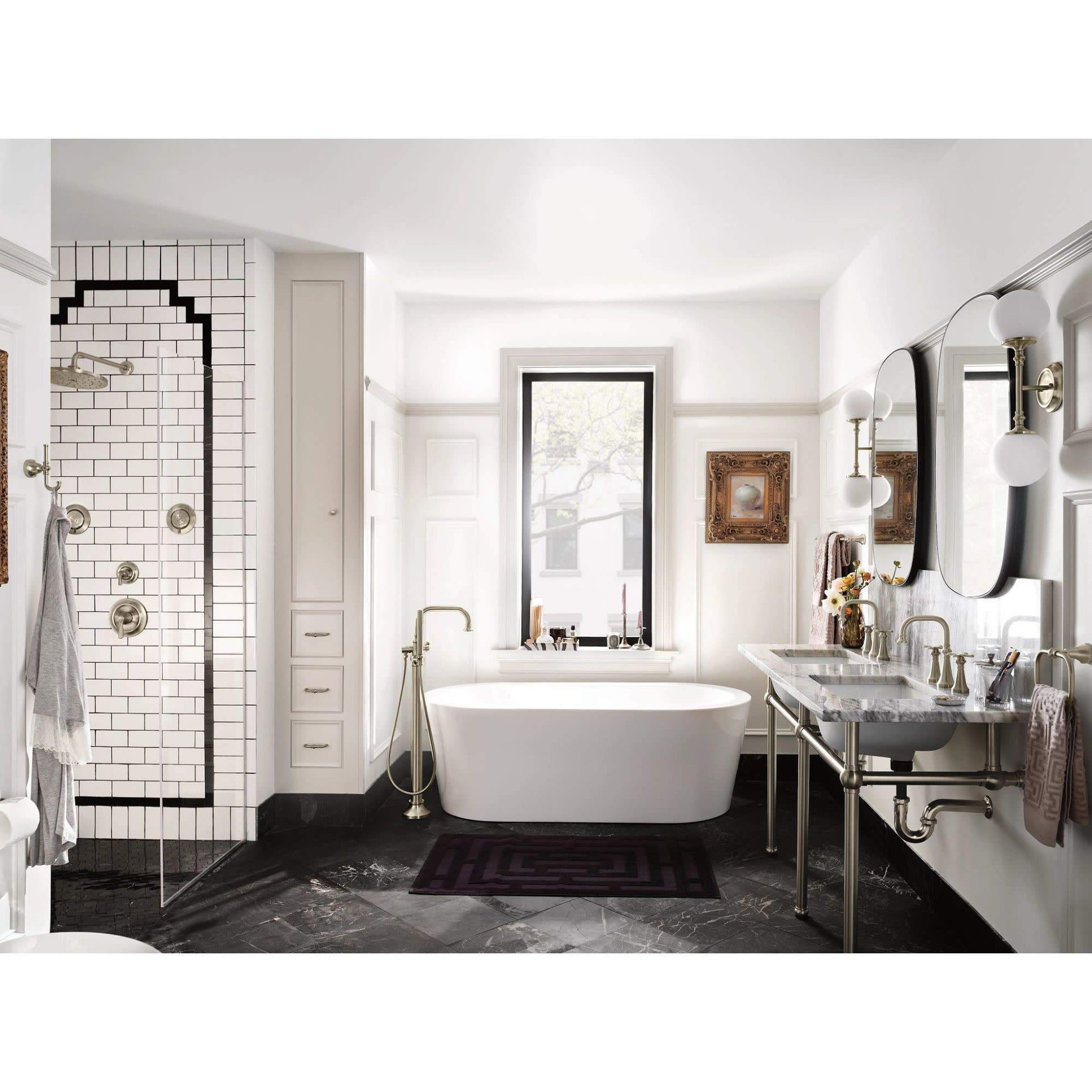 Matte black freestanding tub filler with single handle and curved spout positioned beside white oval bathtub.