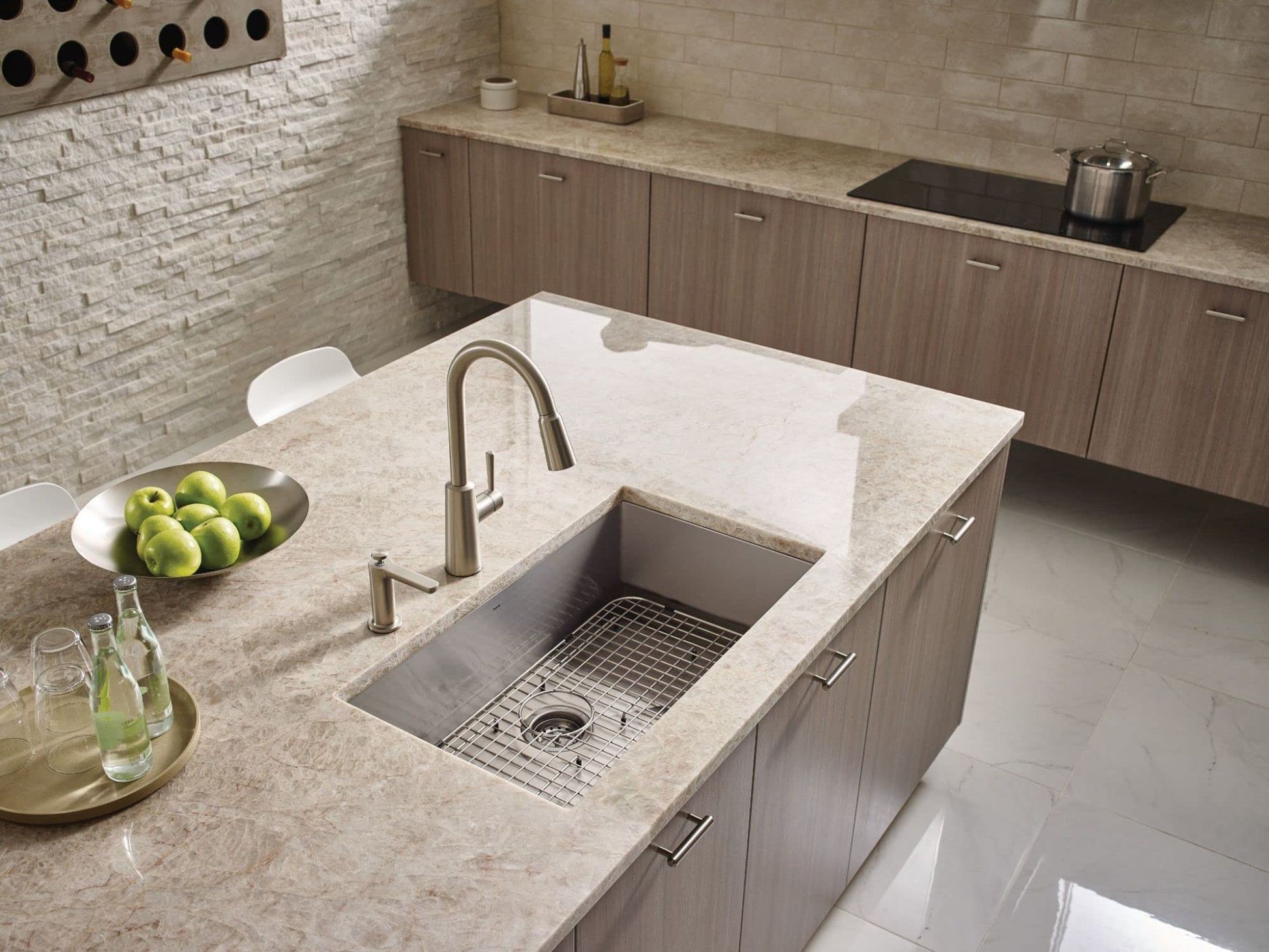 Stainless steel undermount kitchen sink with single bowl and grid strainer in countertop installation.
