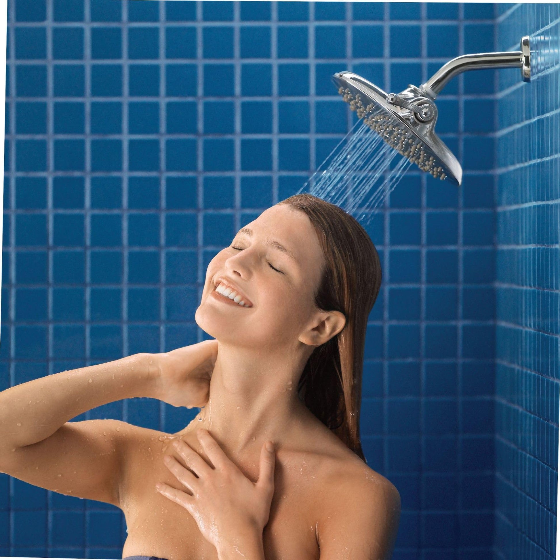 Chrome rain shower head with curved arm mounted on blue tile wall, dispensing water stream.