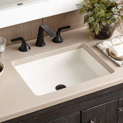 Pearl white rectangular undermount bathroom sink with black three-hole faucet mounted on countertop.