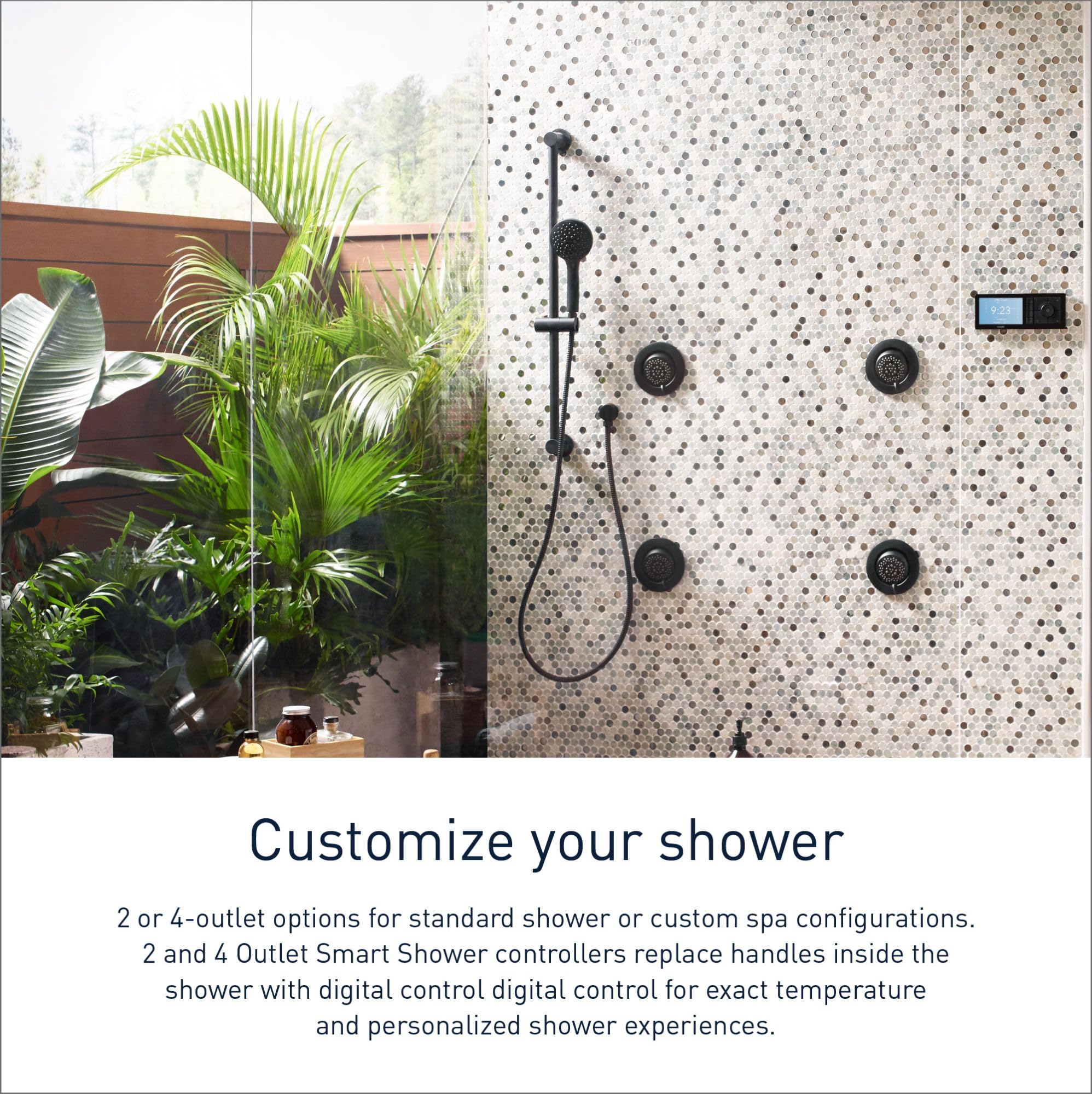 Matte black digital shower controller mounted on speckled tile wall with handheld showerhead and multiple body jets.