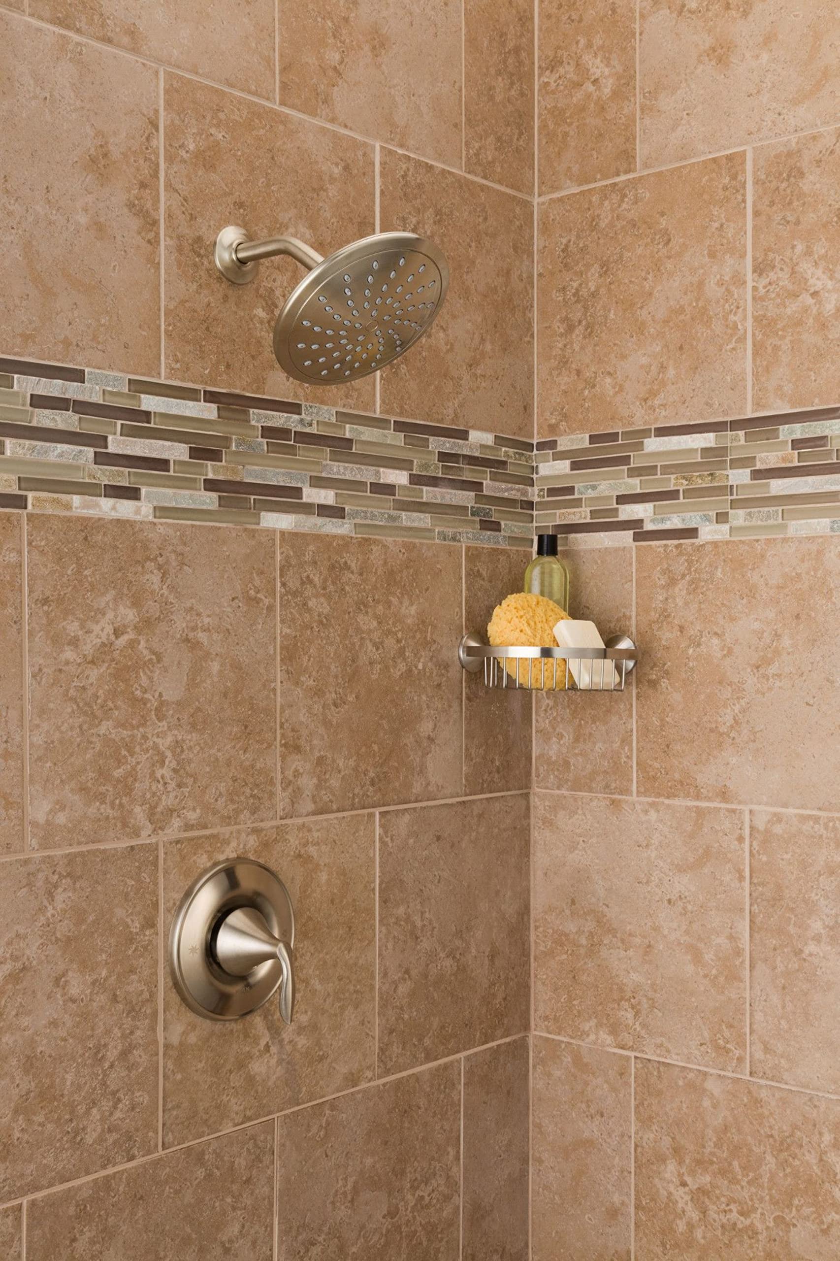 Brushed nickel rain shower head with perforated face mounted on tiled shower wall above valve trim.