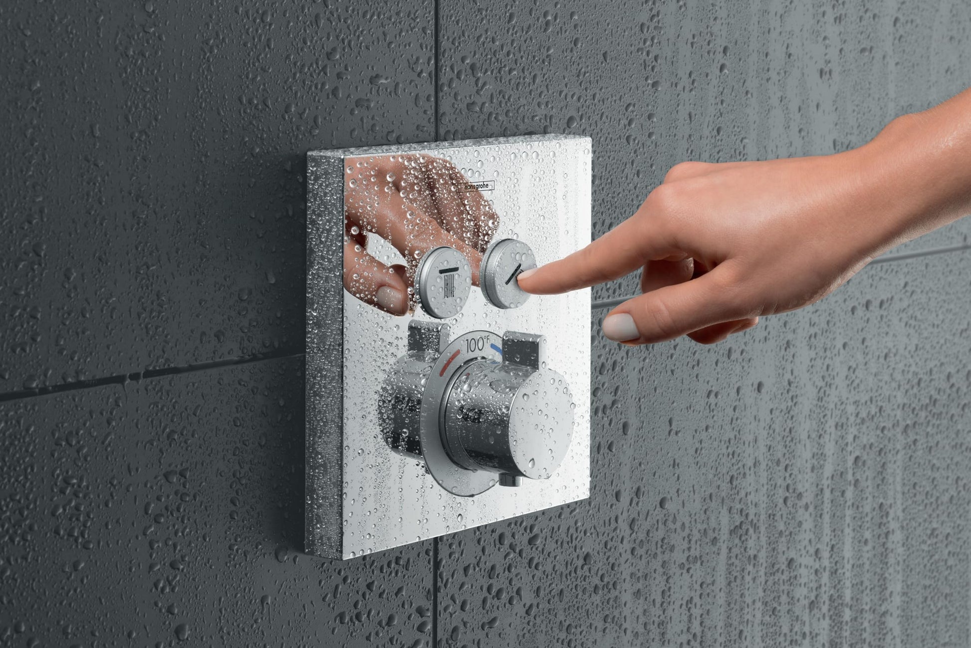Square brushed nickel thermostatic shower valve trim with two control handles mounted on wet tile wall.