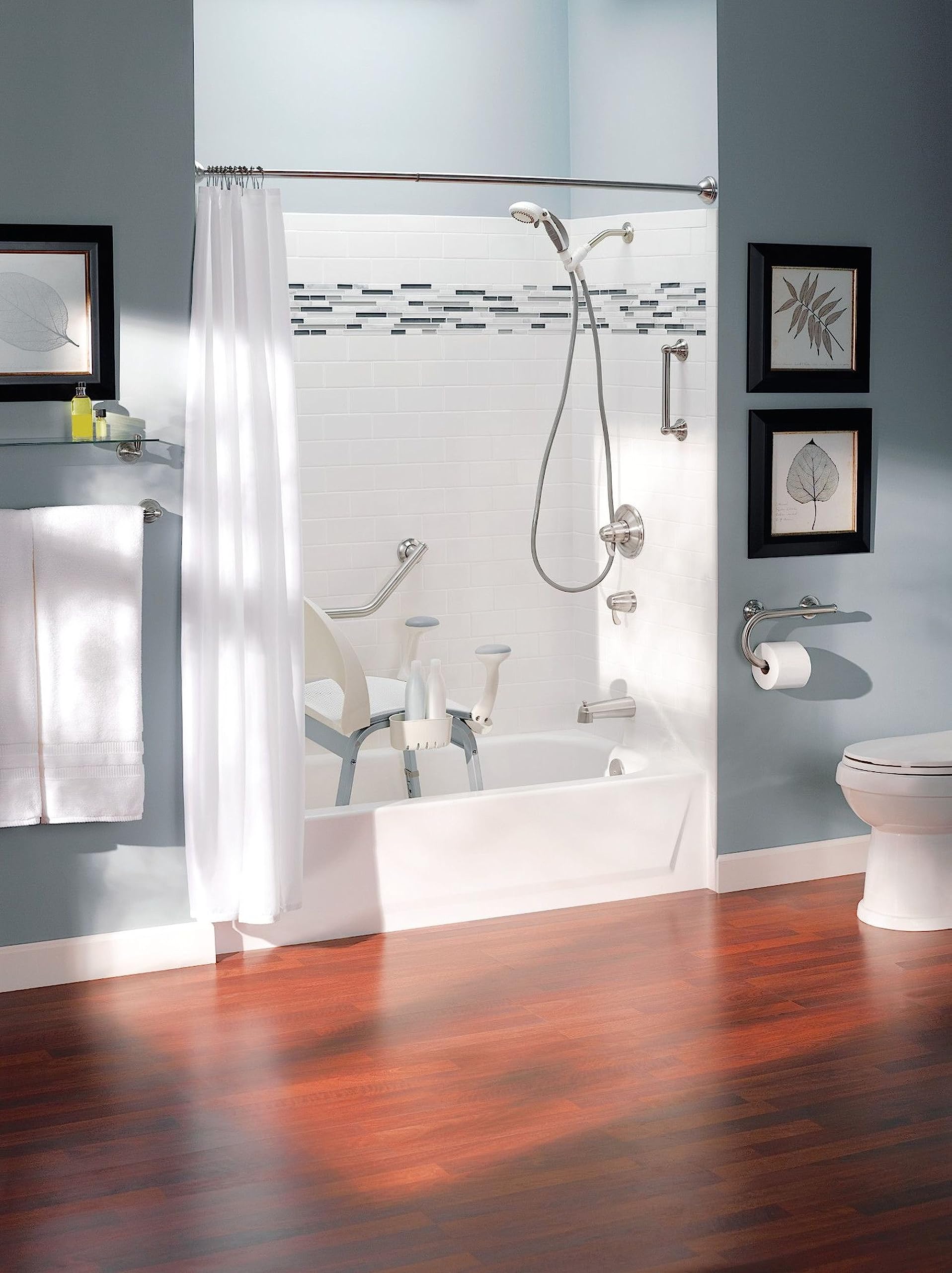 Brushed nickel grab bar with integrated towel bar mounted on shower wall above bathtub with white subway tile surround.