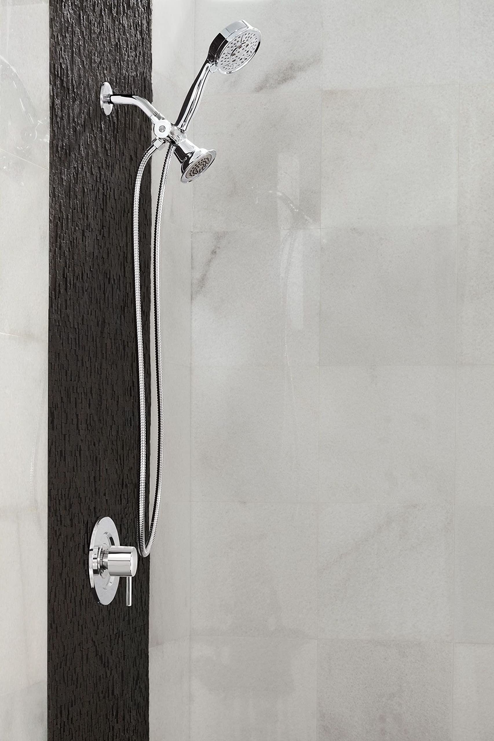 Chrome shower valve trim with handheld showerhead, fixed showerhead, and curved arm mounted on tile wall.