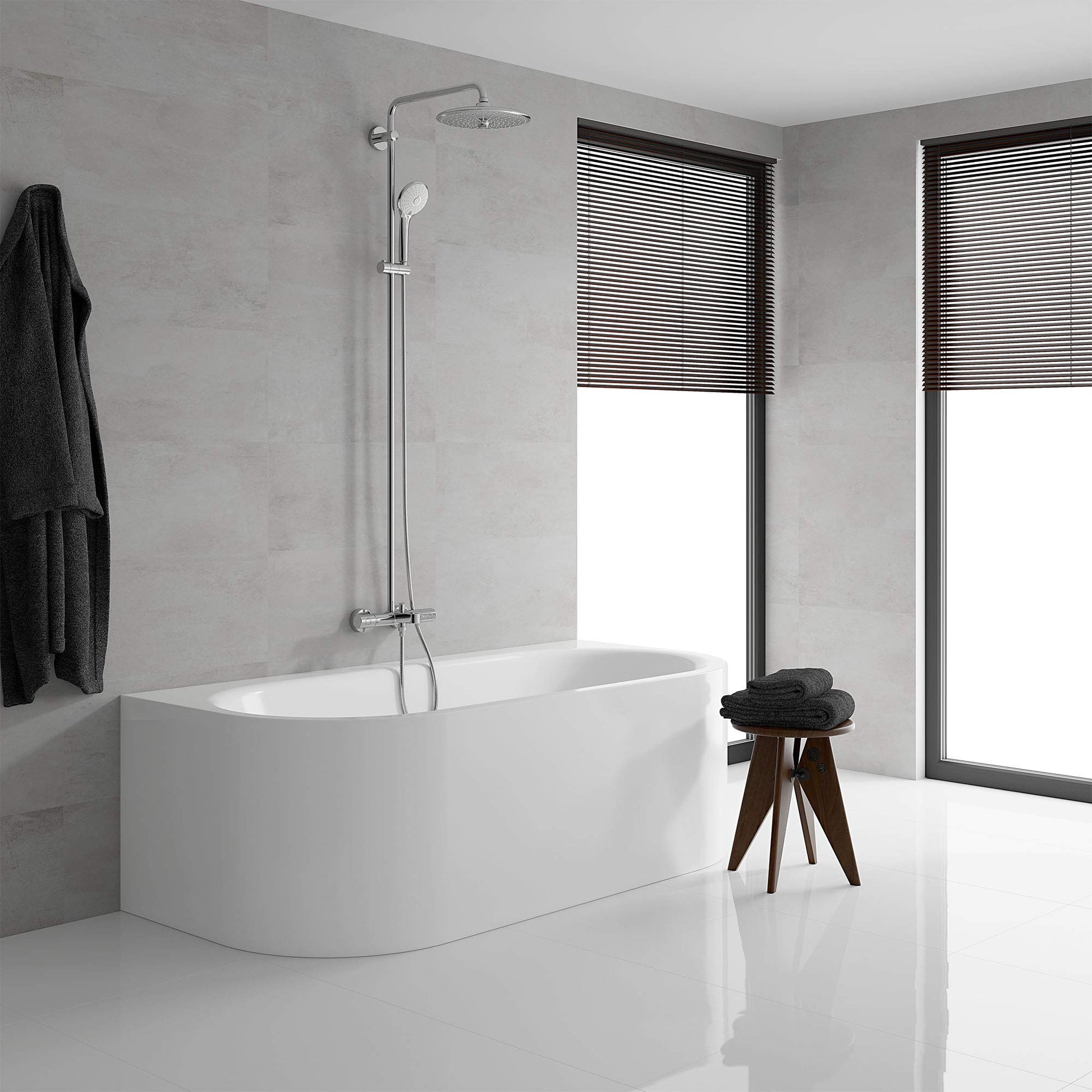 Chrome thermostatic shower system with overhead and handheld showerheads mounted above white bathtub.