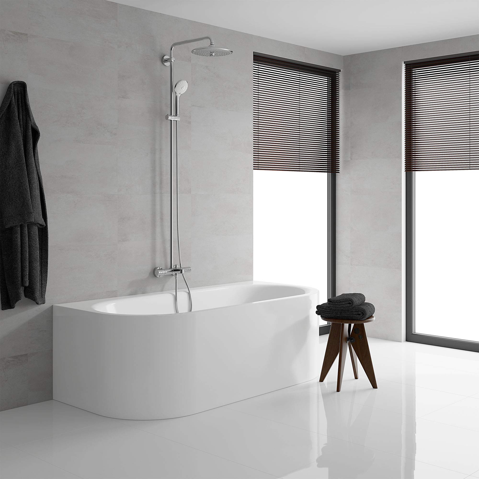 Chrome thermostatic shower system with overhead and handheld showerheads mounted above white bathtub.