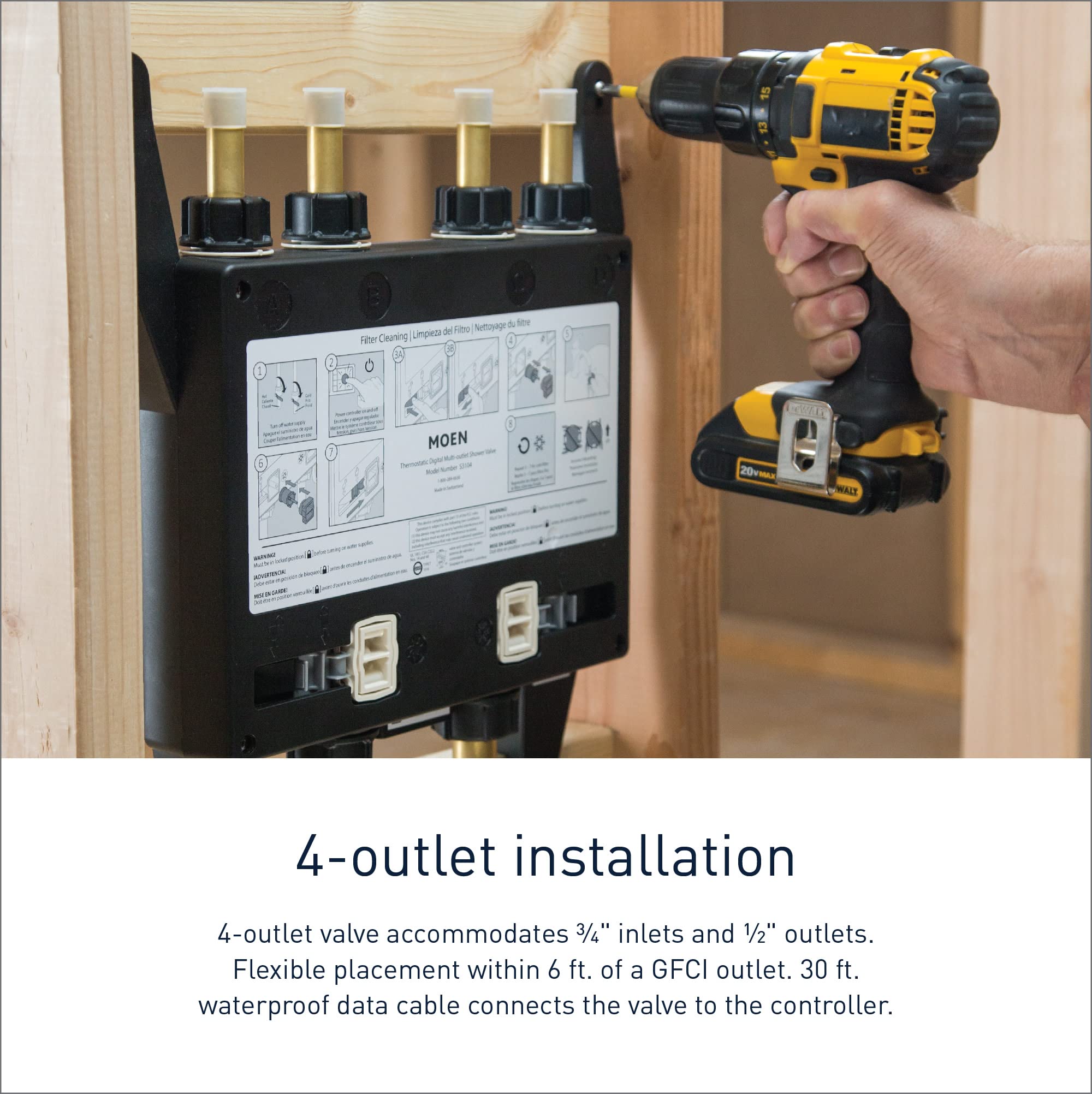 Moen S3104 digital valve with four brass outlets mounted in wall cavity during installation with drill.