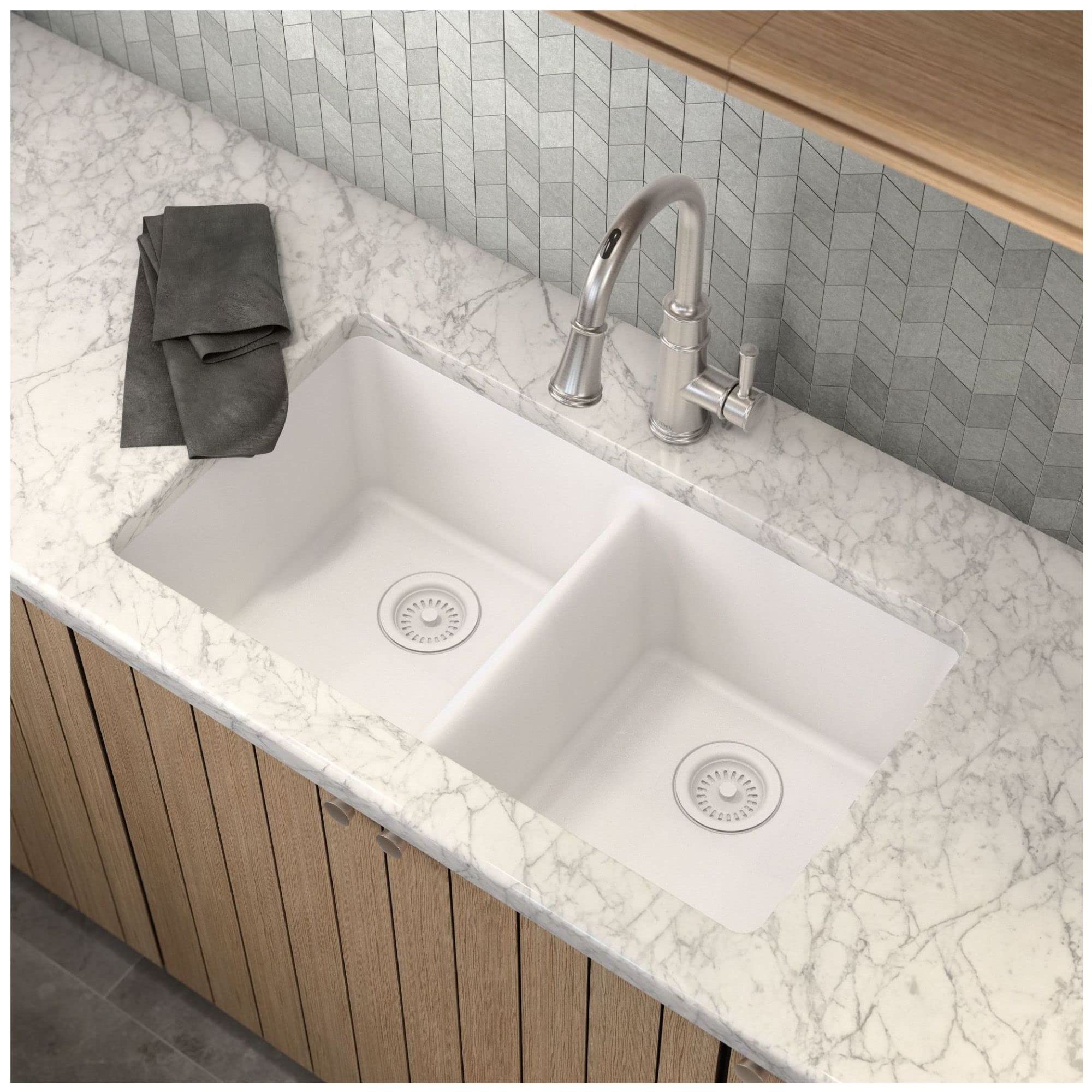White undermount double bowl kitchen sink with drain strainers, installed in marble countertop with faucet.