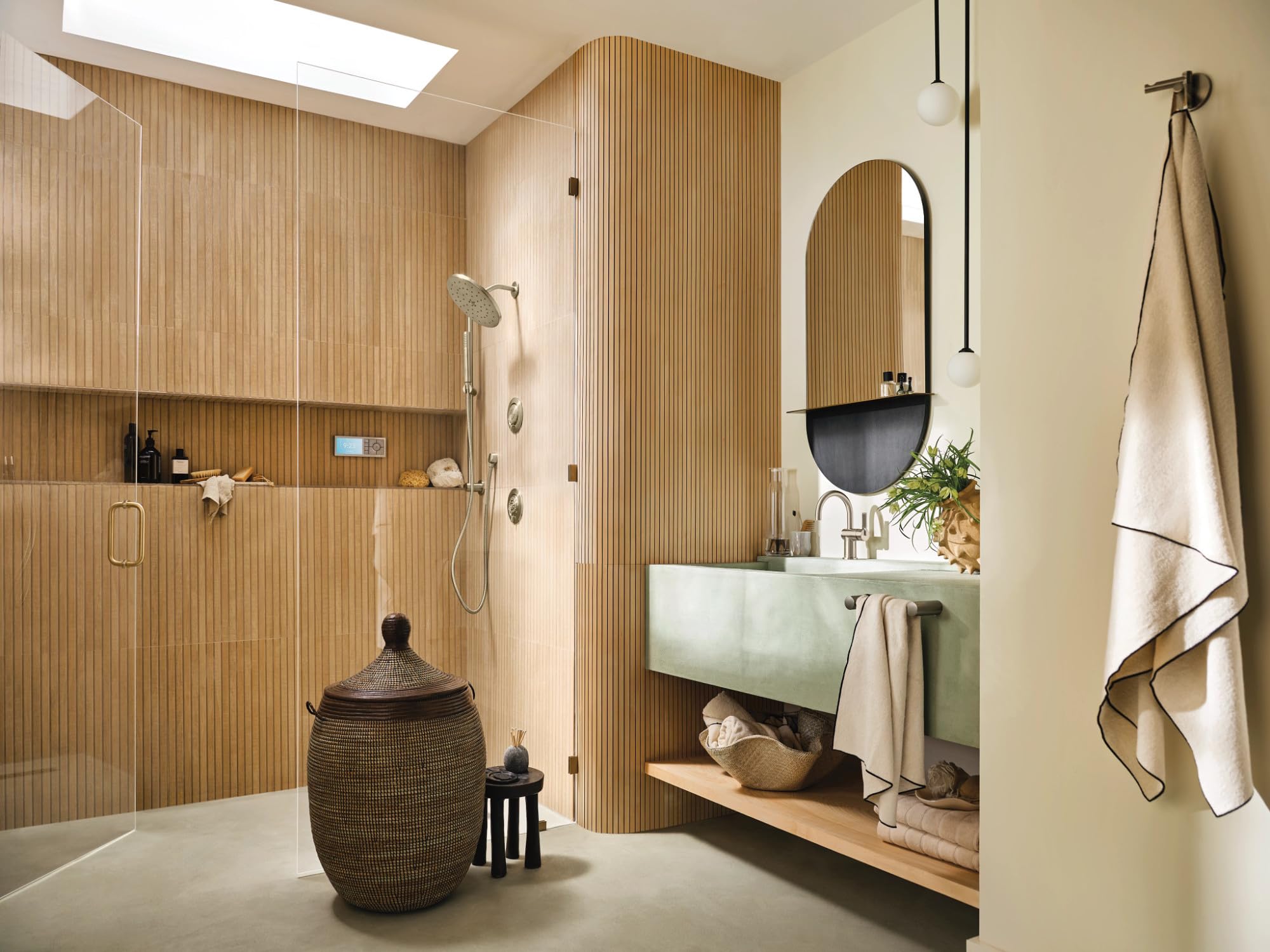 Brushed nickel handheld showerhead with metal hose and vertical slide bar mounted on wooden bathroom wall.