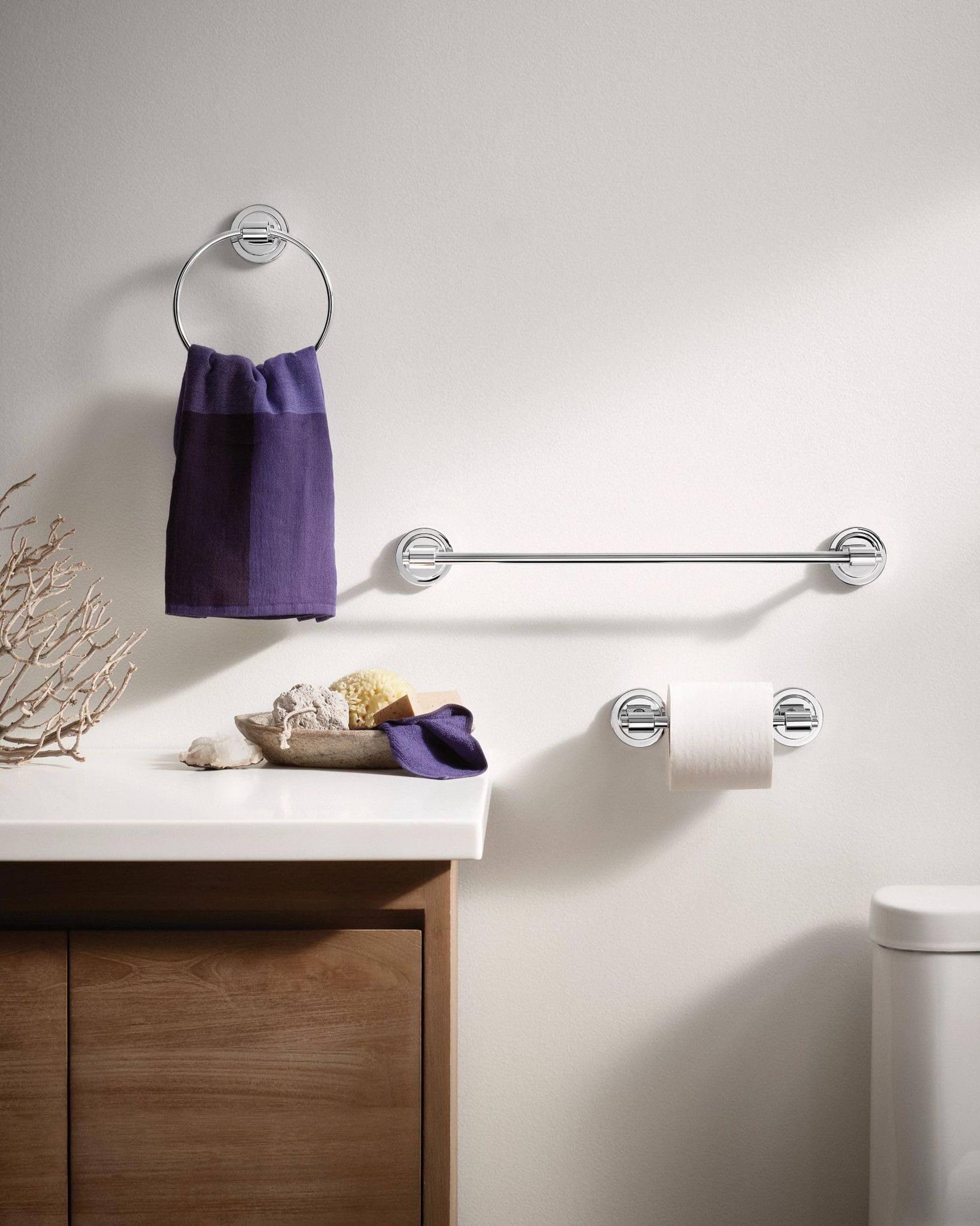 Chrome pivoting toilet paper holder with circular wall mounting brackets and a horizontal arm holding a roll of white toilet 