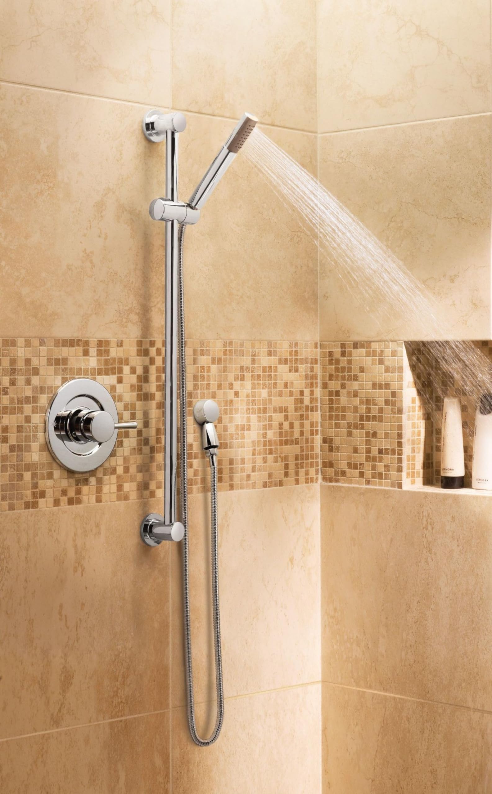 Brushed nickel handheld showerhead with metal hose and slide bar mounted on tile shower wall with valve.