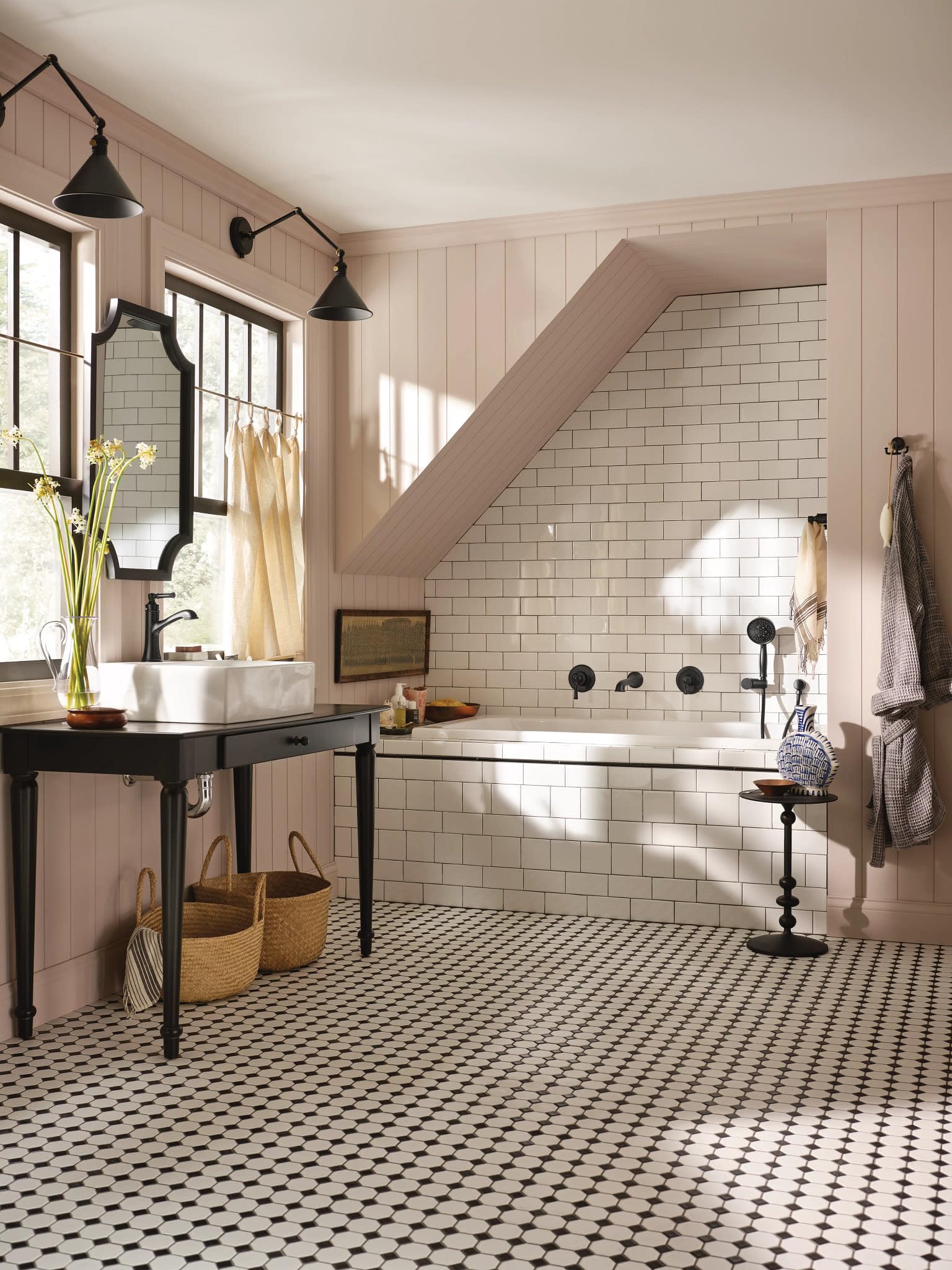 Matte black single-handle bathroom sink faucet with curved spout mounted on white vessel sink in farmhouse bathroom.