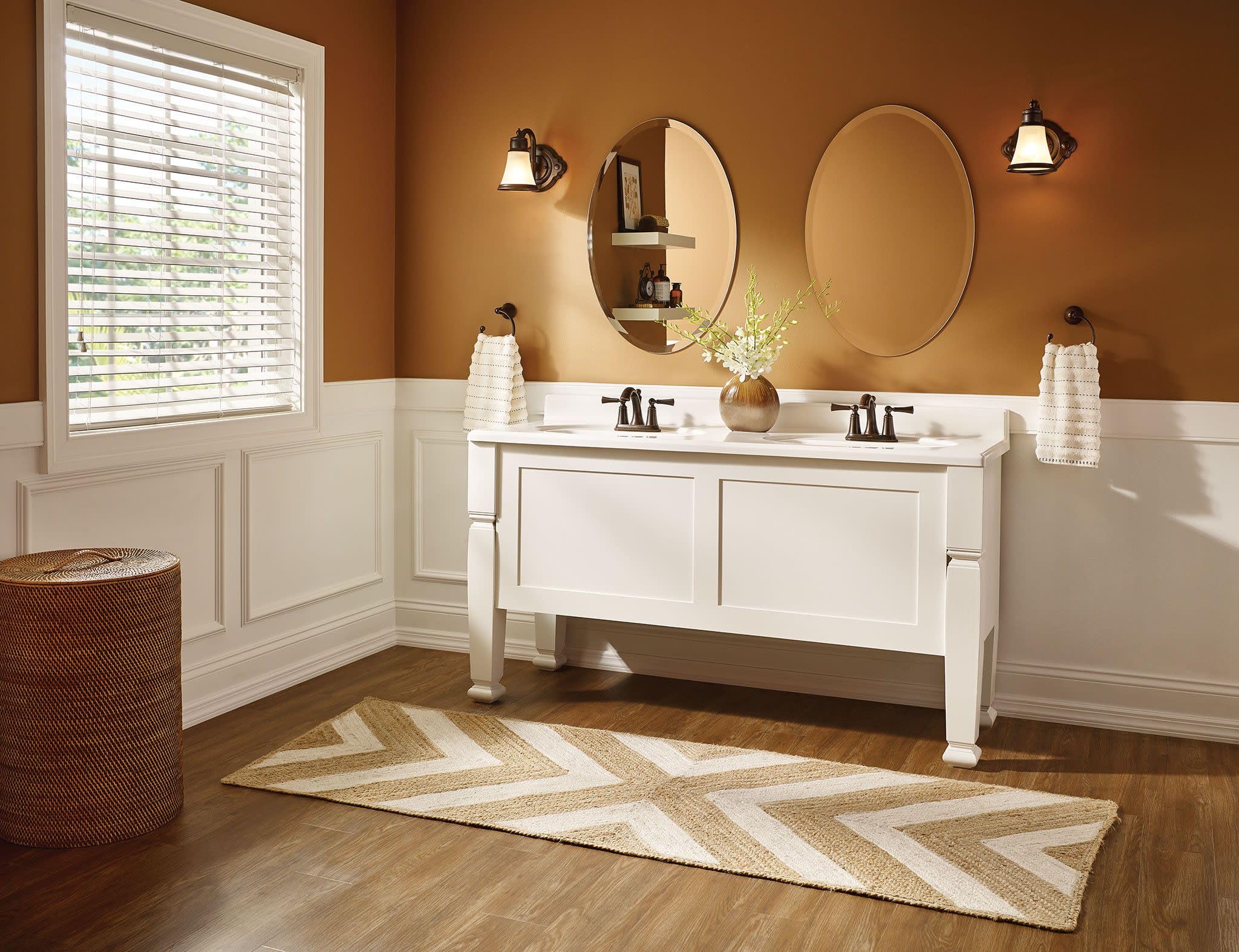 Brushed nickel two-handle high arc faucet with curved spout on white bathroom vanity.