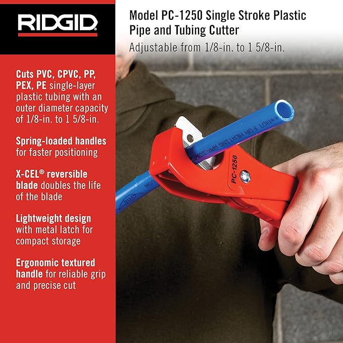 Red and blue RIDGID PC-1250 plastic pipe cutter being held in hand with blue pipe inserted in cutting head.