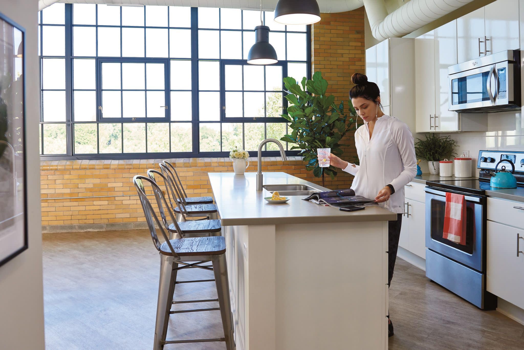 Stainless steel single-handle kitchen faucet with pulldown sprayer mounted above white countertop sink.