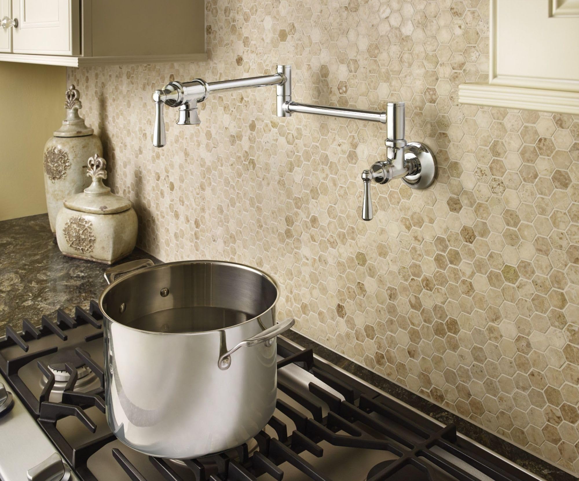 Chrome wall-mounted pot filler faucet with folding swing arm extended over stovetop with large pot.