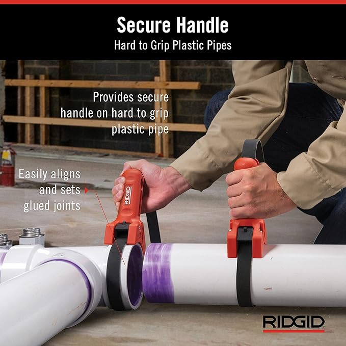 Red RIDGID STRAPLOCK pipe handle strap wrench gripping white PVC pipes with purple tape marked on joints.