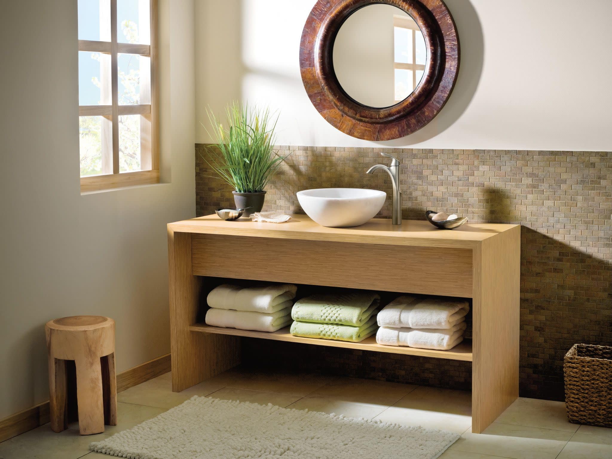 Chrome single-handle faucet mounted above white vessel sink on wooden bathroom vanity.