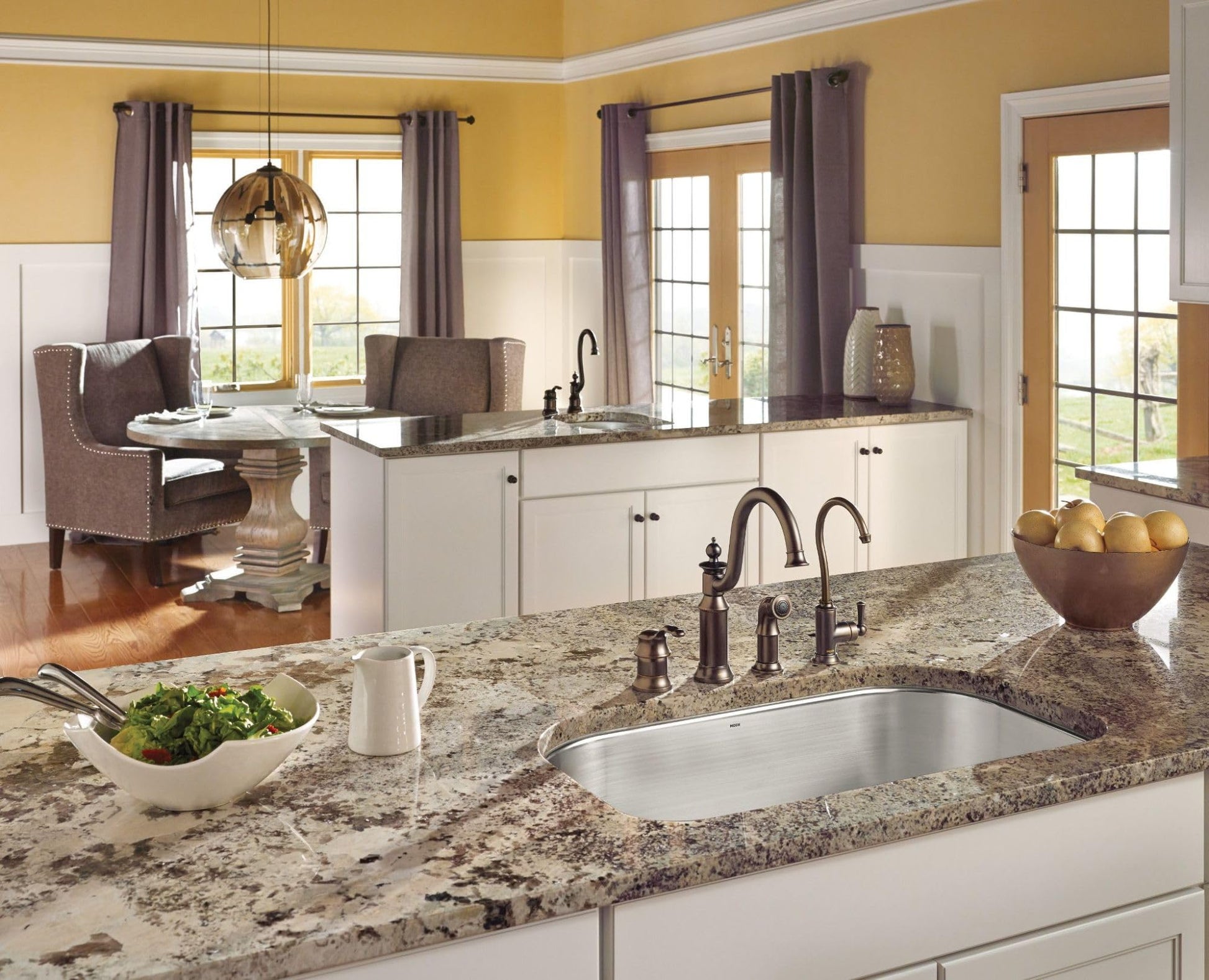 Oil rubbed bronze wall-mounted swing arm pot filler faucet with curved spout positioned above kitchen sink.