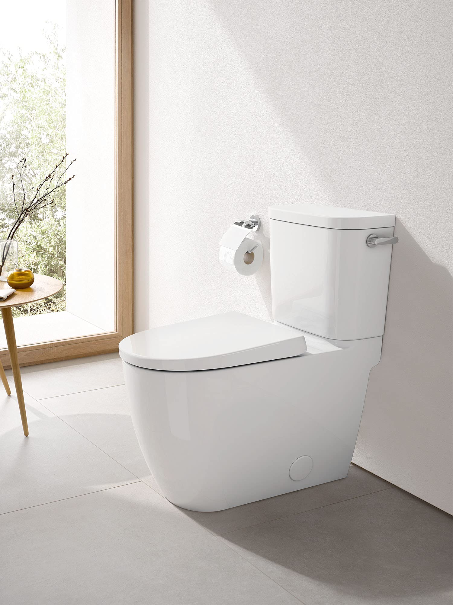 White two-piece elongated toilet with closed seat and tank, right-hand trip lever visible on tank.