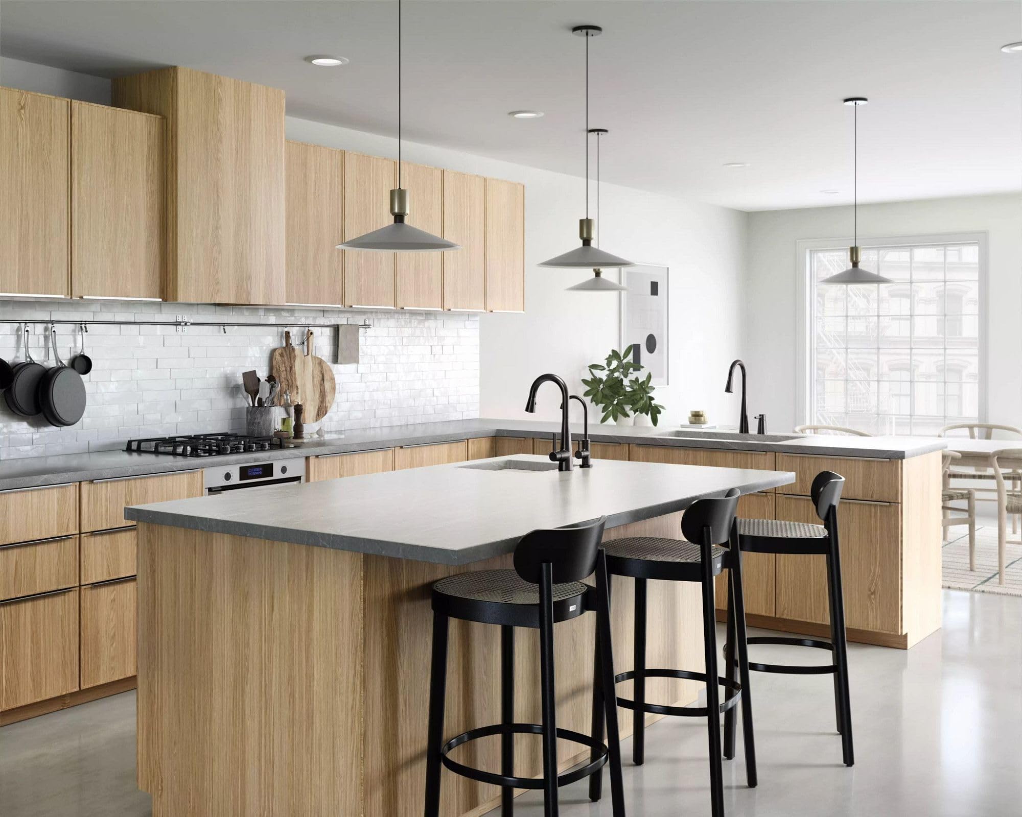Black and stainless steel single-handle pulldown bar faucet with high arc spout installed in kitchen sink.