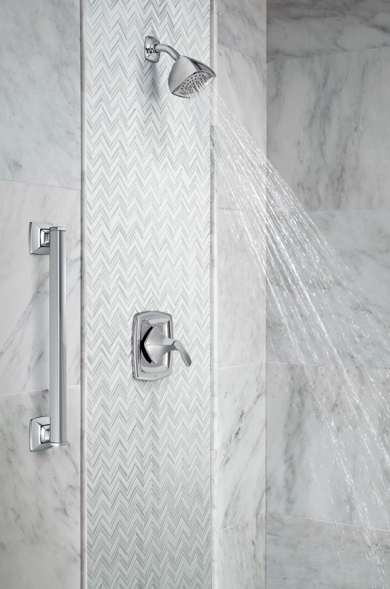 Polished nickel shower valve trim with single lever handle, showerhead, and volume control mounted on marble tile wall.