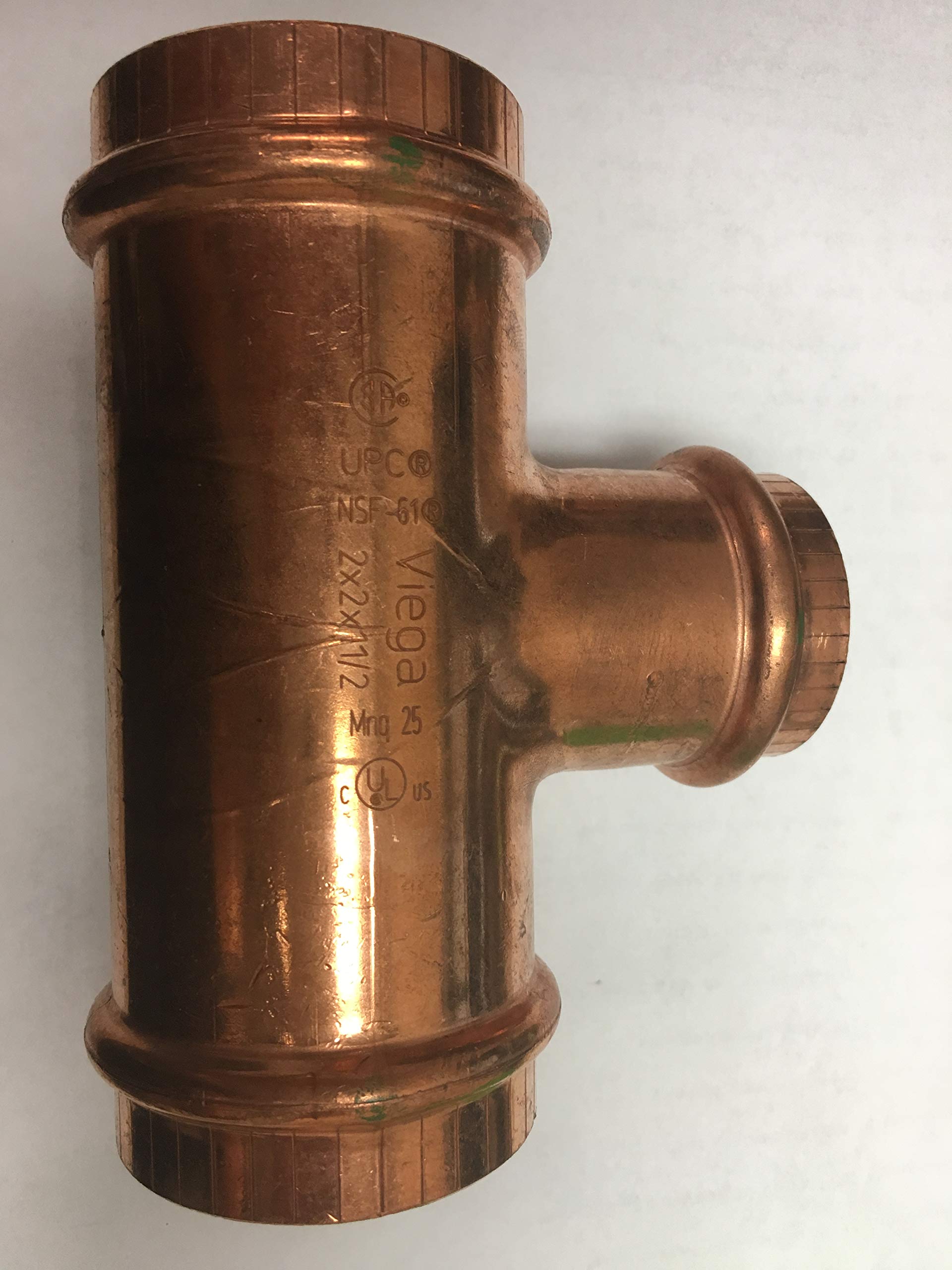 Copper press tee fitting with three connection points and embossed manufacturer markings on the surface.
