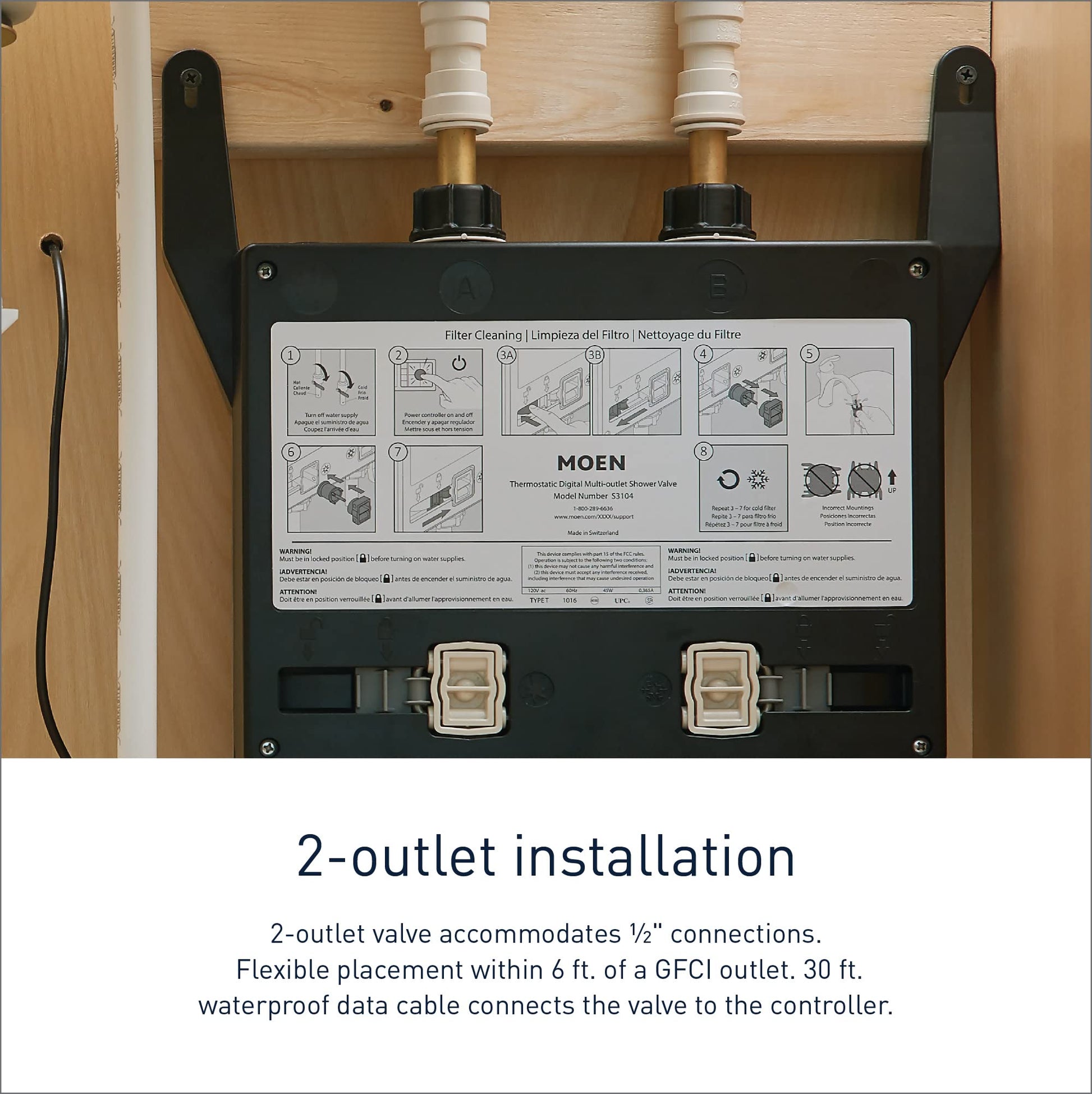 Moen S3102 digital valve with two brass outlets, two solenoid cartridges, and instruction label mounted in wall cavity.