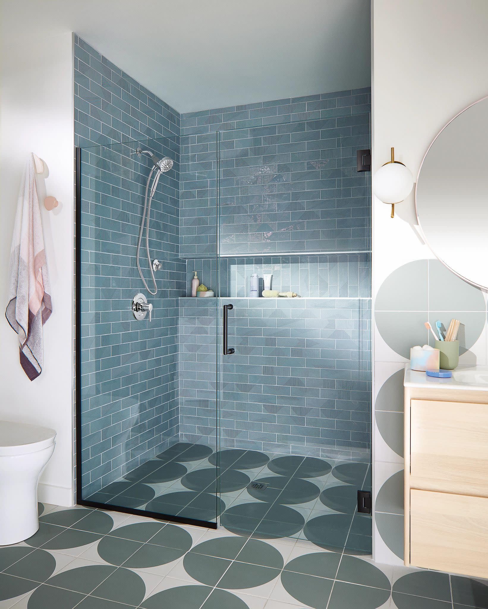 Chrome hand shower with six spray settings mounted on blue subway tile shower wall.