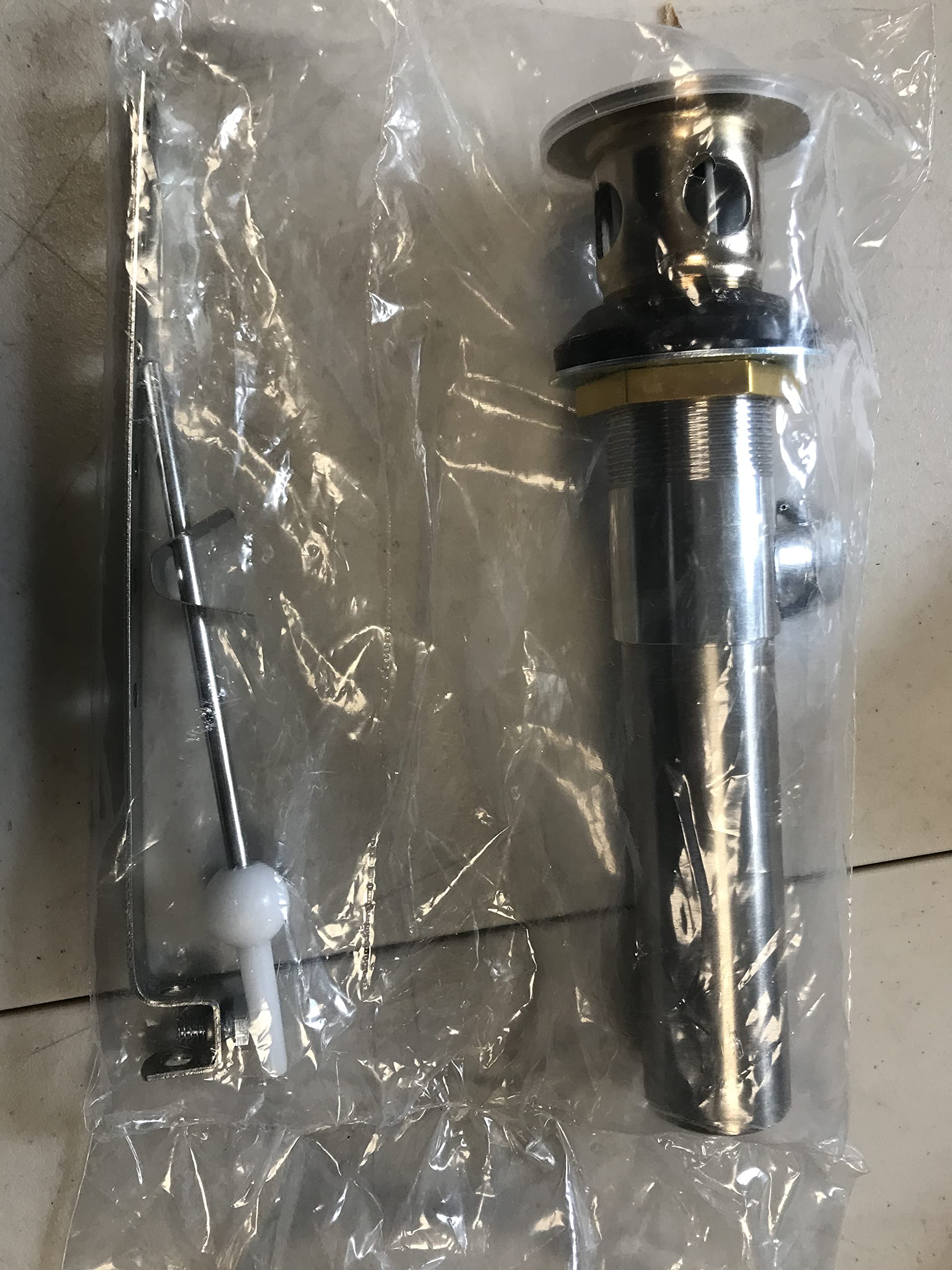 Push-button pop-up drain assembly with gold and brushed metal finish, including overflow mechanism and connecting rod.