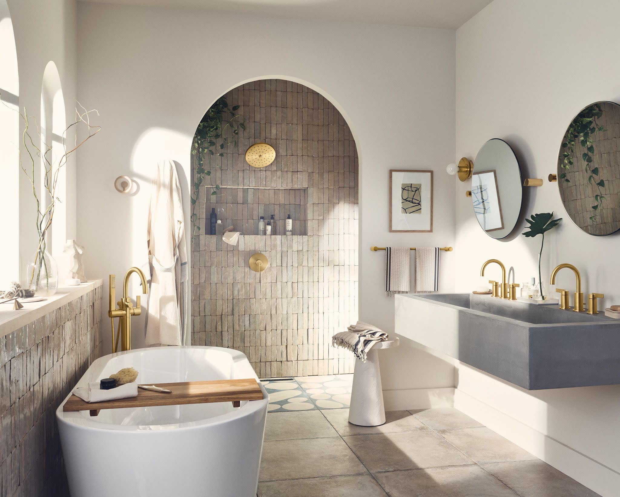 Brushed gold two-handle high arc faucet with curved spout for widespread bathroom sink installation.