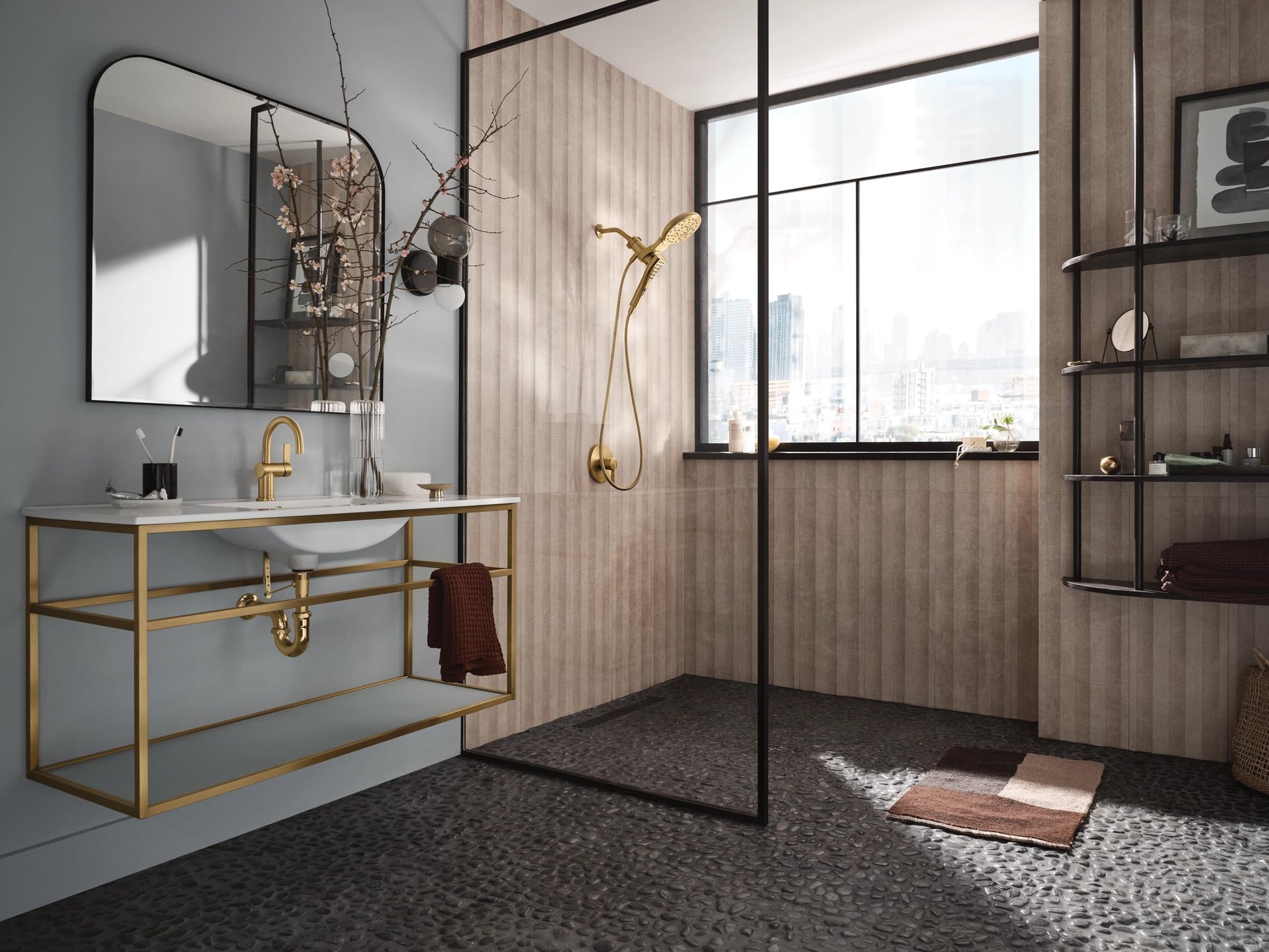 Brushed gold dual shower head combo with curved handheld wand and wall-mounted fixture in modern bathroom.