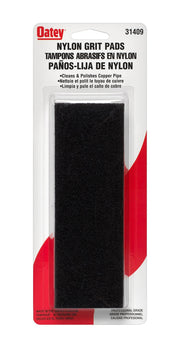 Black nylon grit pad, 2 inches by 6 inches, in clear plastic packaging with Oatey branding.