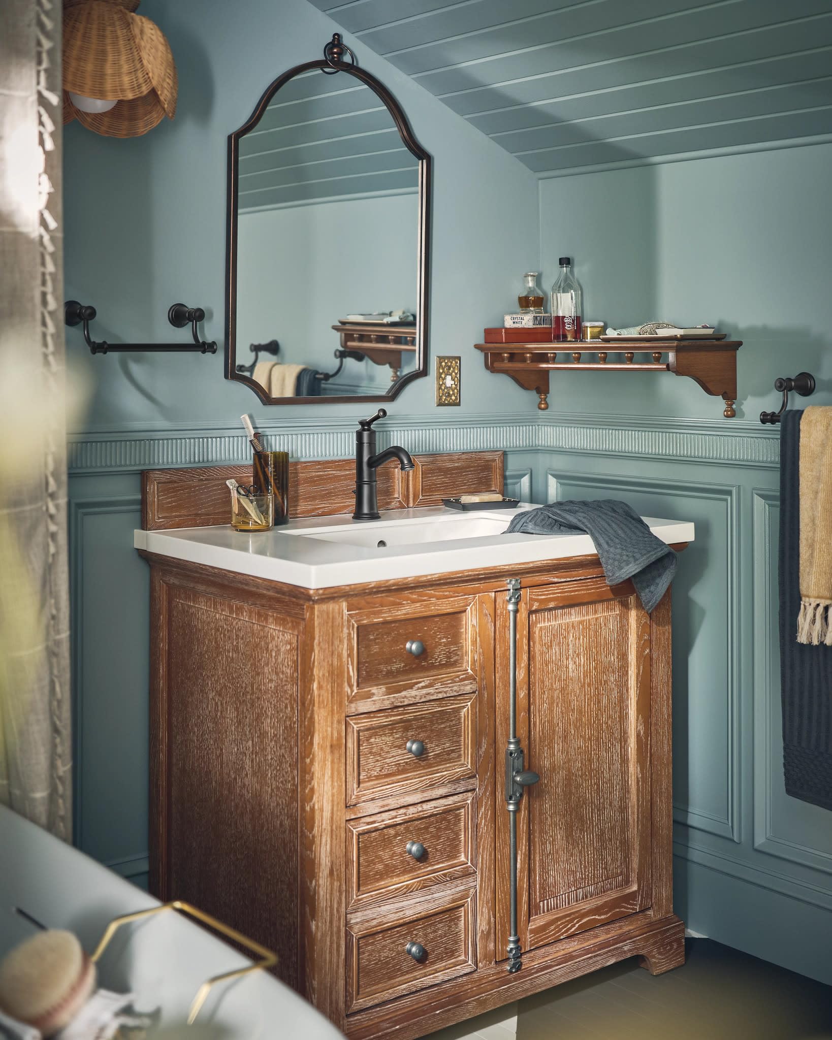 Matte black single-handle bathroom faucet with curved spout installed on white sink above wooden vanity.